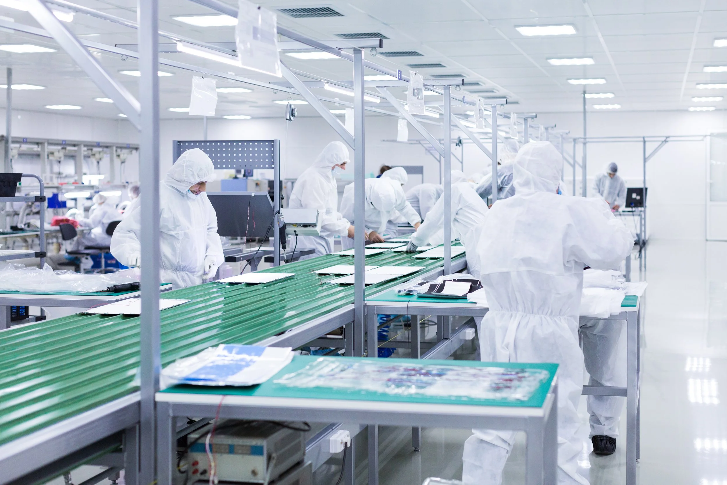 Technicians in cleanroom suits working in a controlled laboratory environment