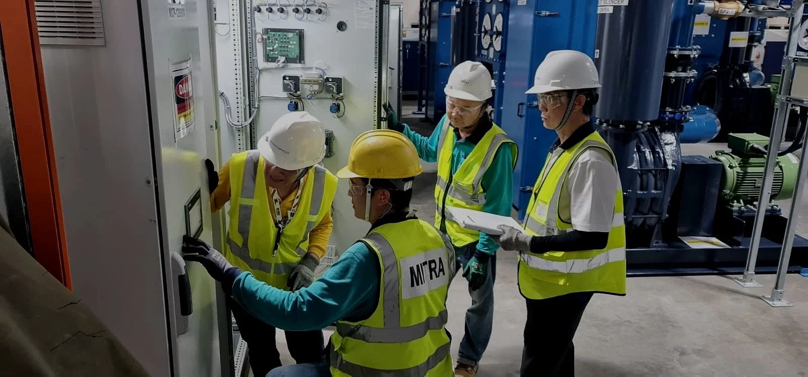 4 men in hard hats carrying out testing and commissioning work