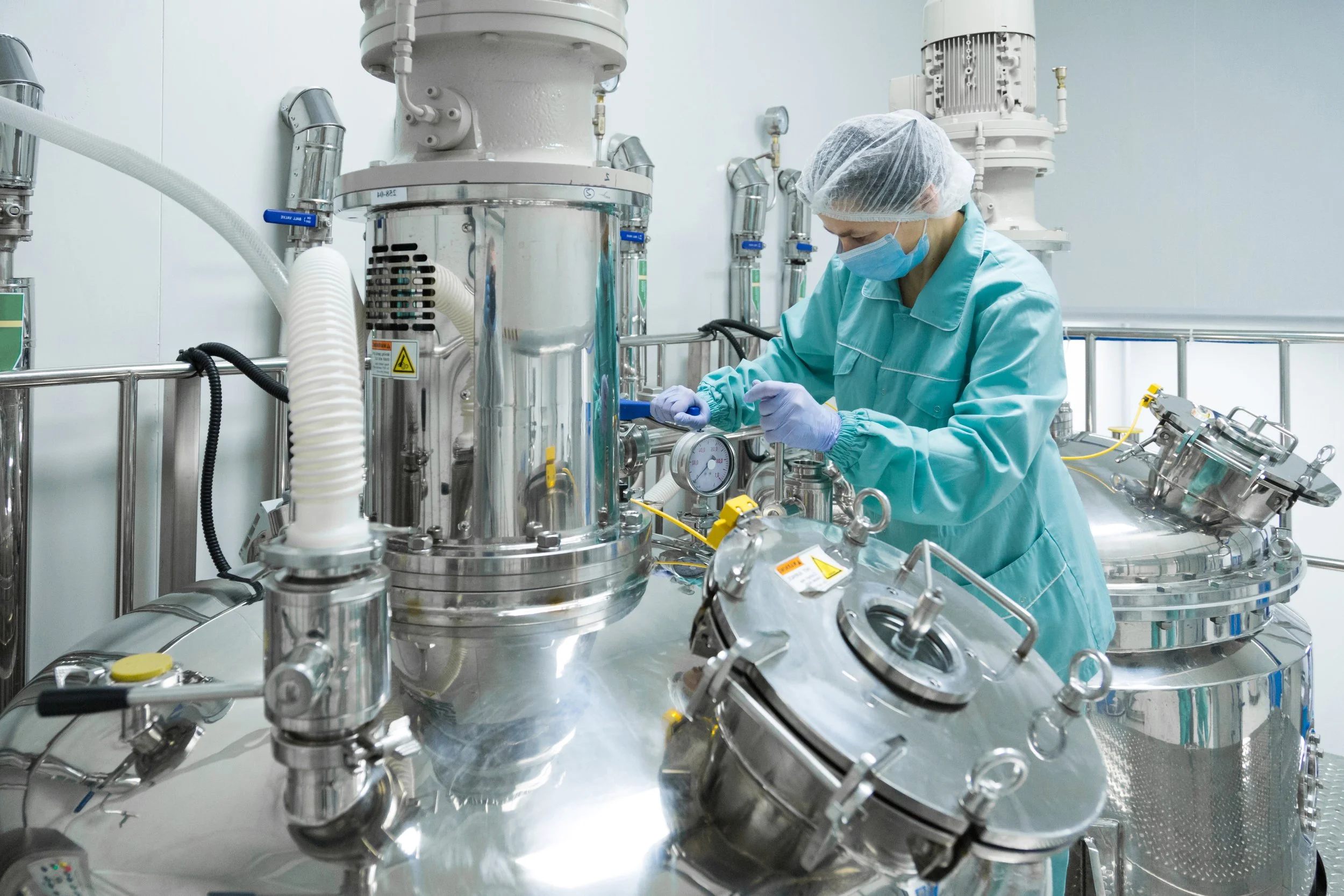 Pharmaceutical production operator in protective clothing handling fine powders