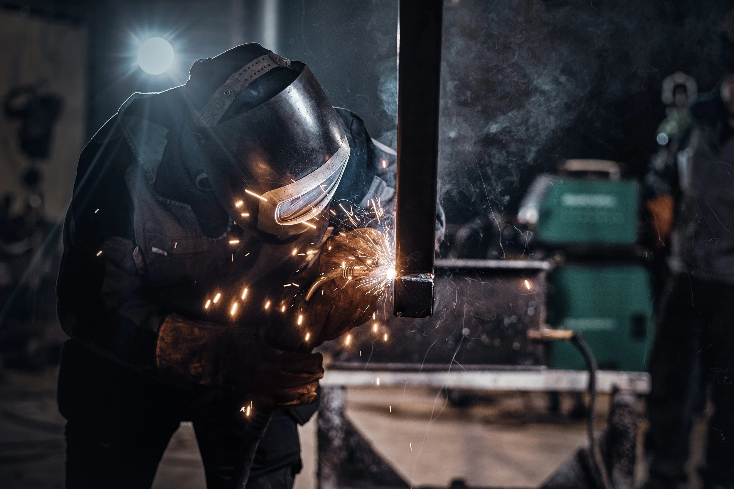 Welder working on a metal rail section, generating fume requiring extraction