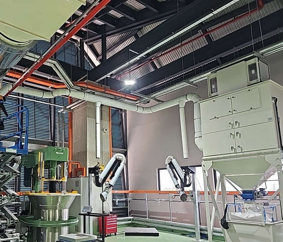 Dust collection system with suction arms at a thermoplastics manufacturer