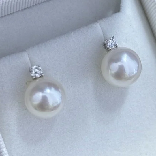Pearl earrings with rhinestone studs in a jewelry box.
