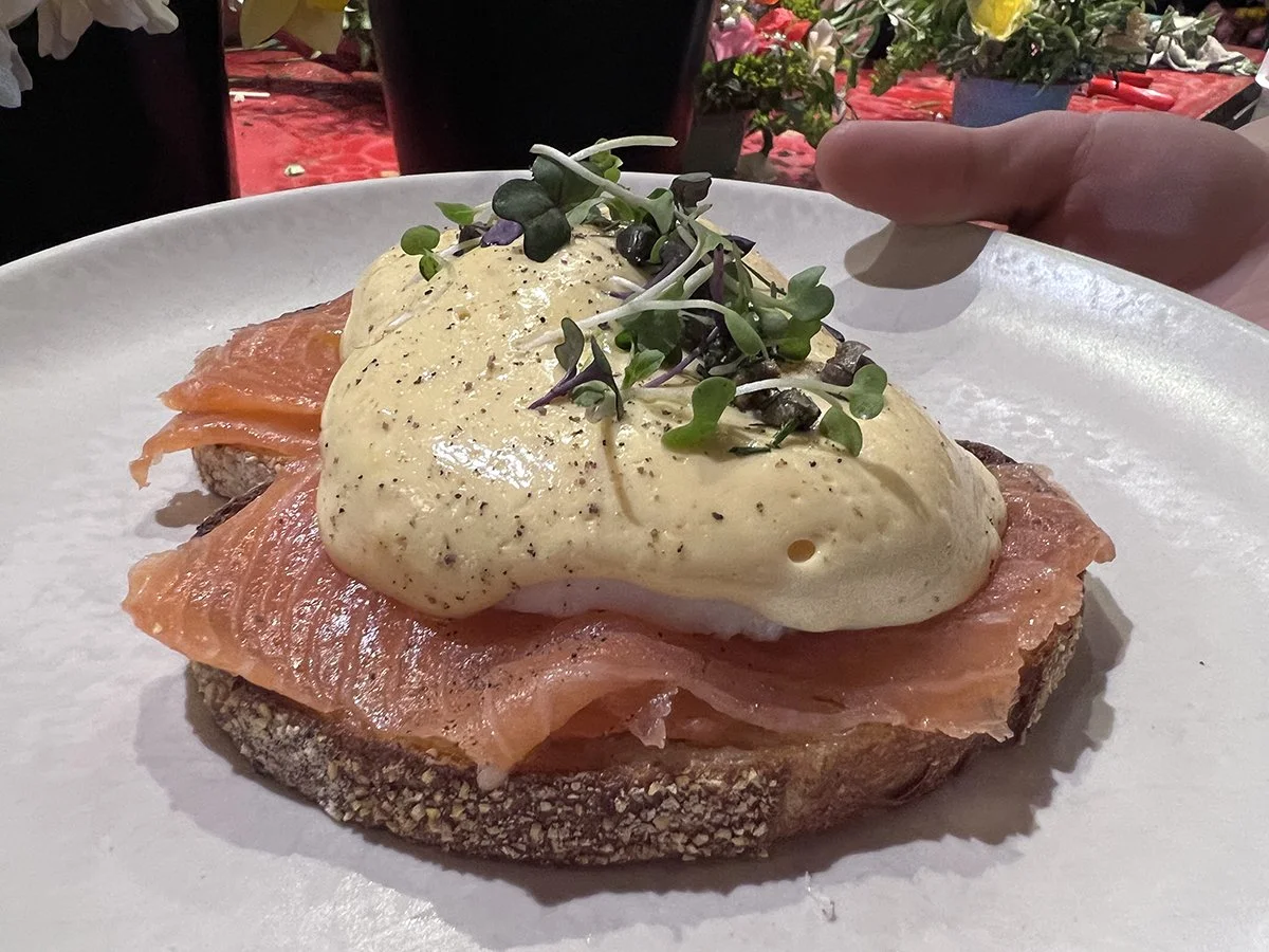 Open-faced salmon and egg breakfast with microgreens on toasted bread.