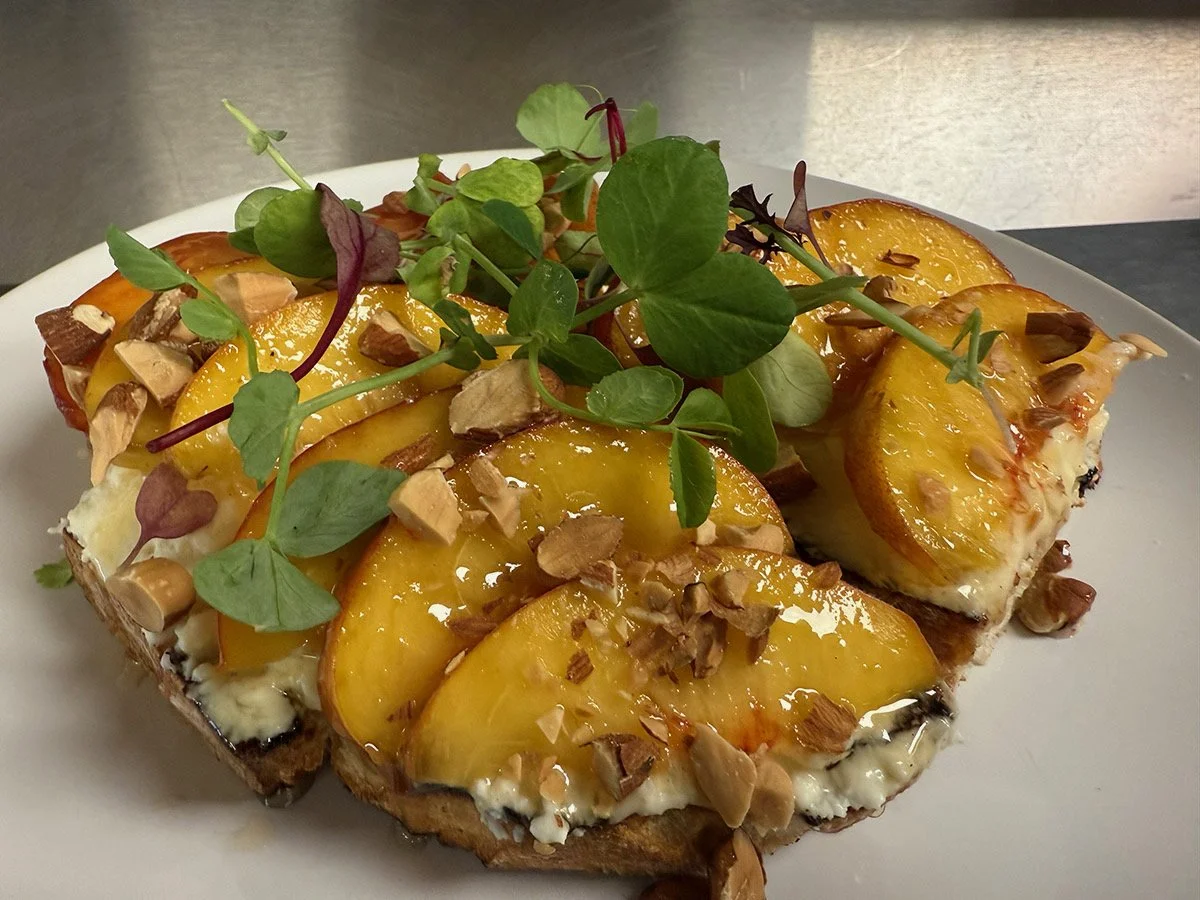 Peach and chopped nut toastgarnished with fresh microgreens.