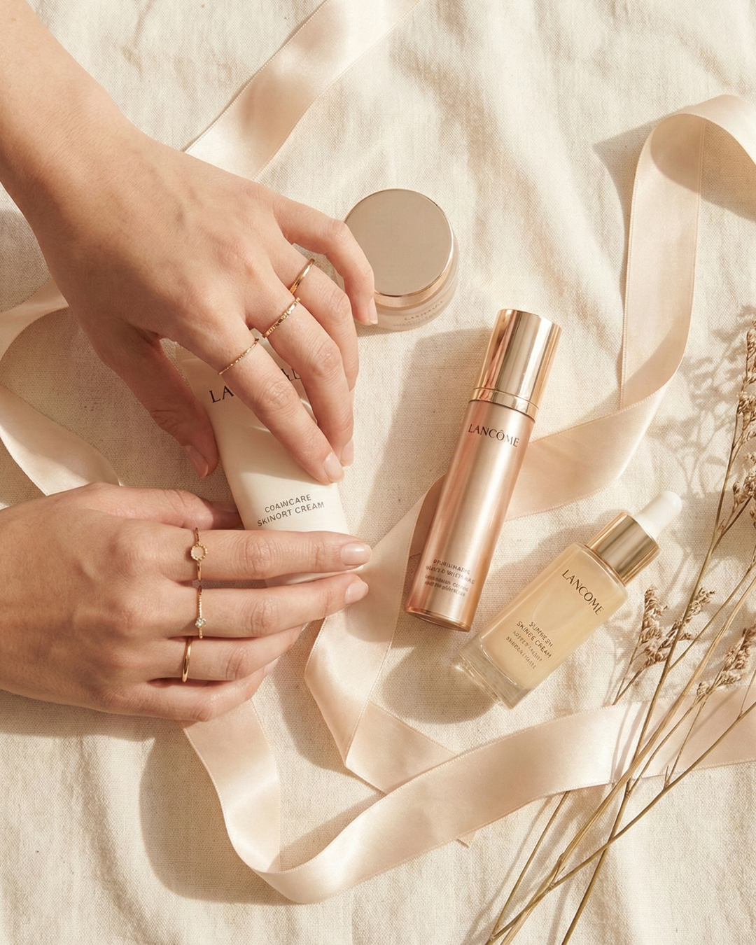 Overhead view of luxury beauty products and silk ribbon styled for a high-end content shoot, representing creative art direction.