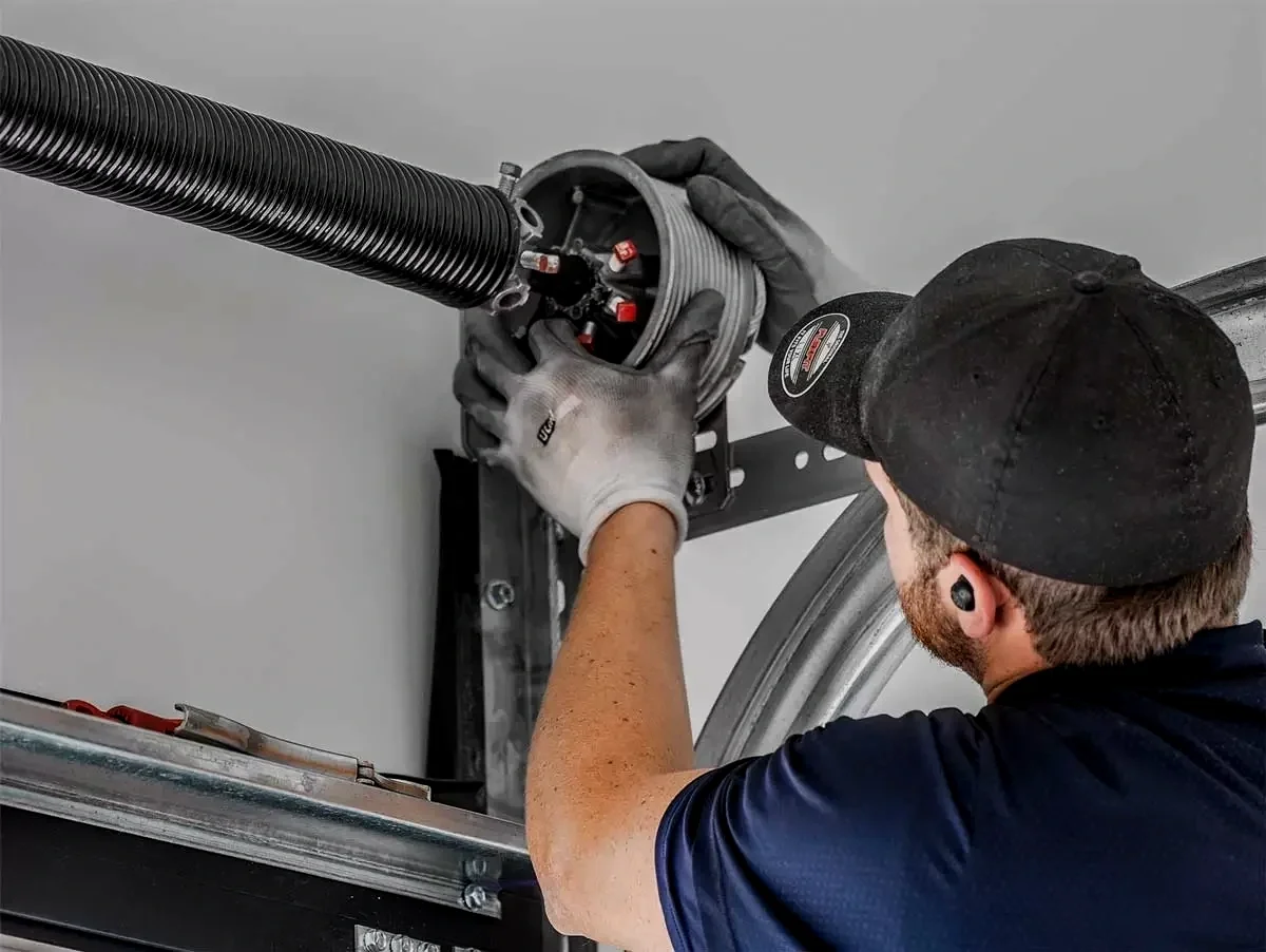 Garage door technician repairing a broken spring in Lemon Grove, CA