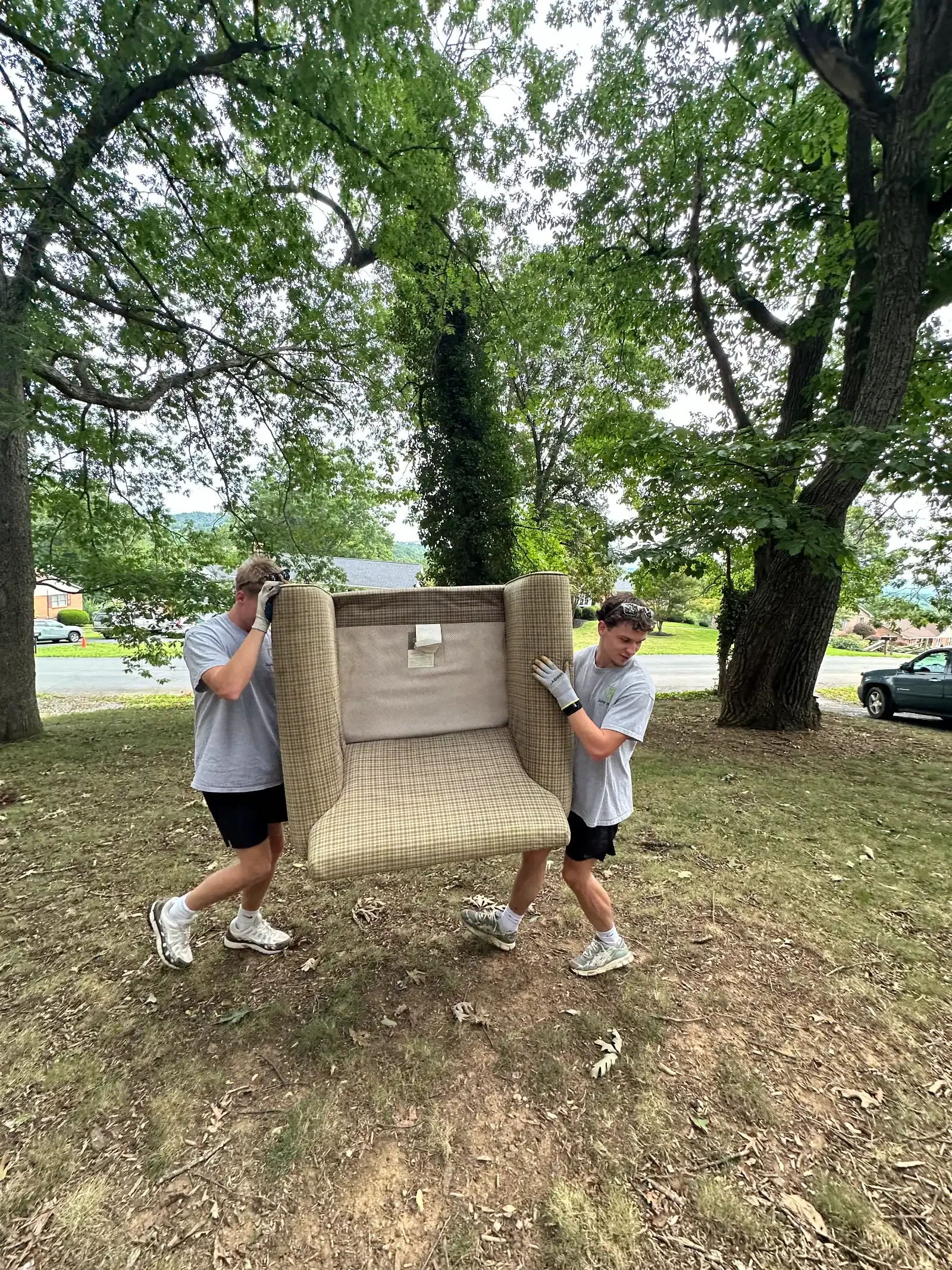 Junk Bros crew carrying a usable armchair for donation or responsible furniture removal in Virginia