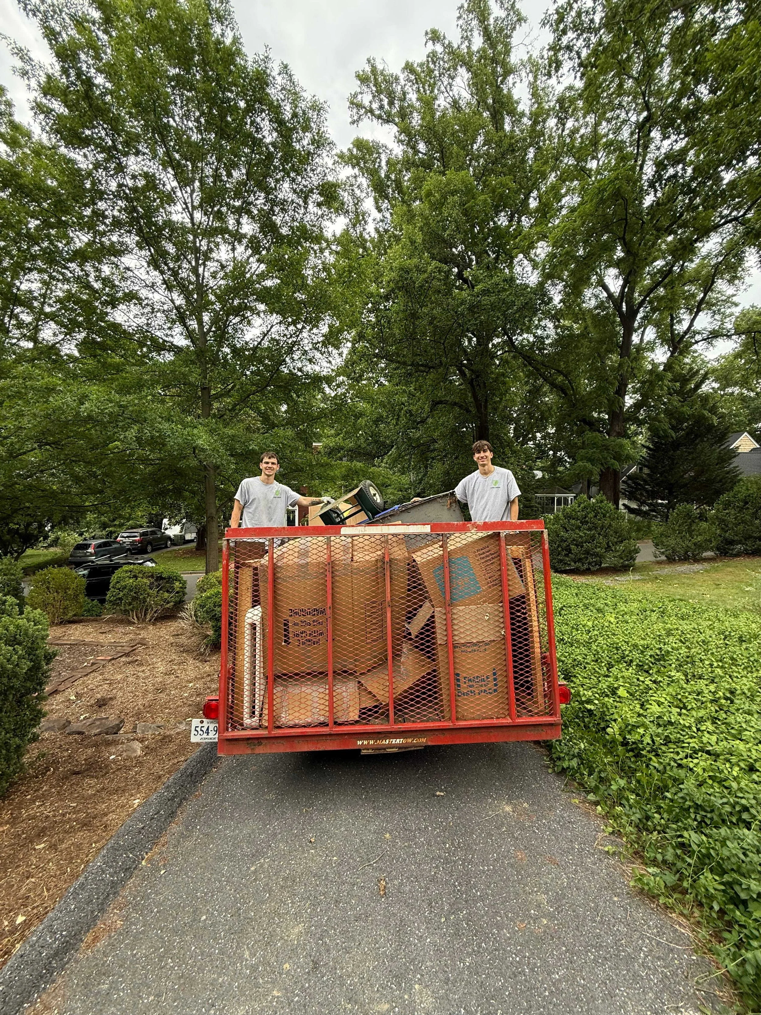Junk Bros crew loading unwanted items into a junk removal trailer in Virginia