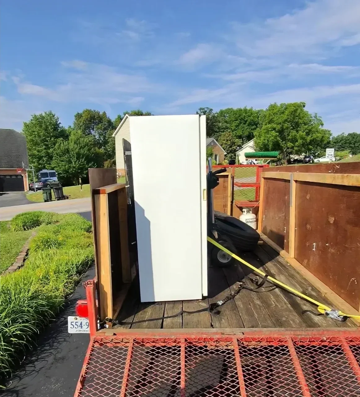 Refrigerator secured in a Junk Bros trailer during an appliance removal job