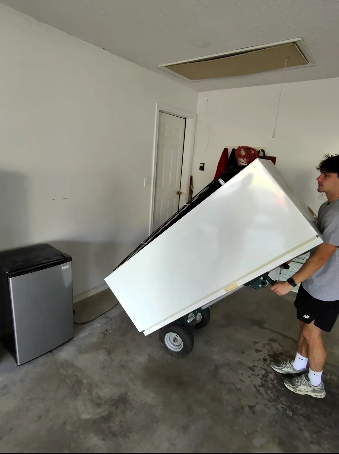Junk Bros crew member moving a refrigerator out of a home for appliance removal