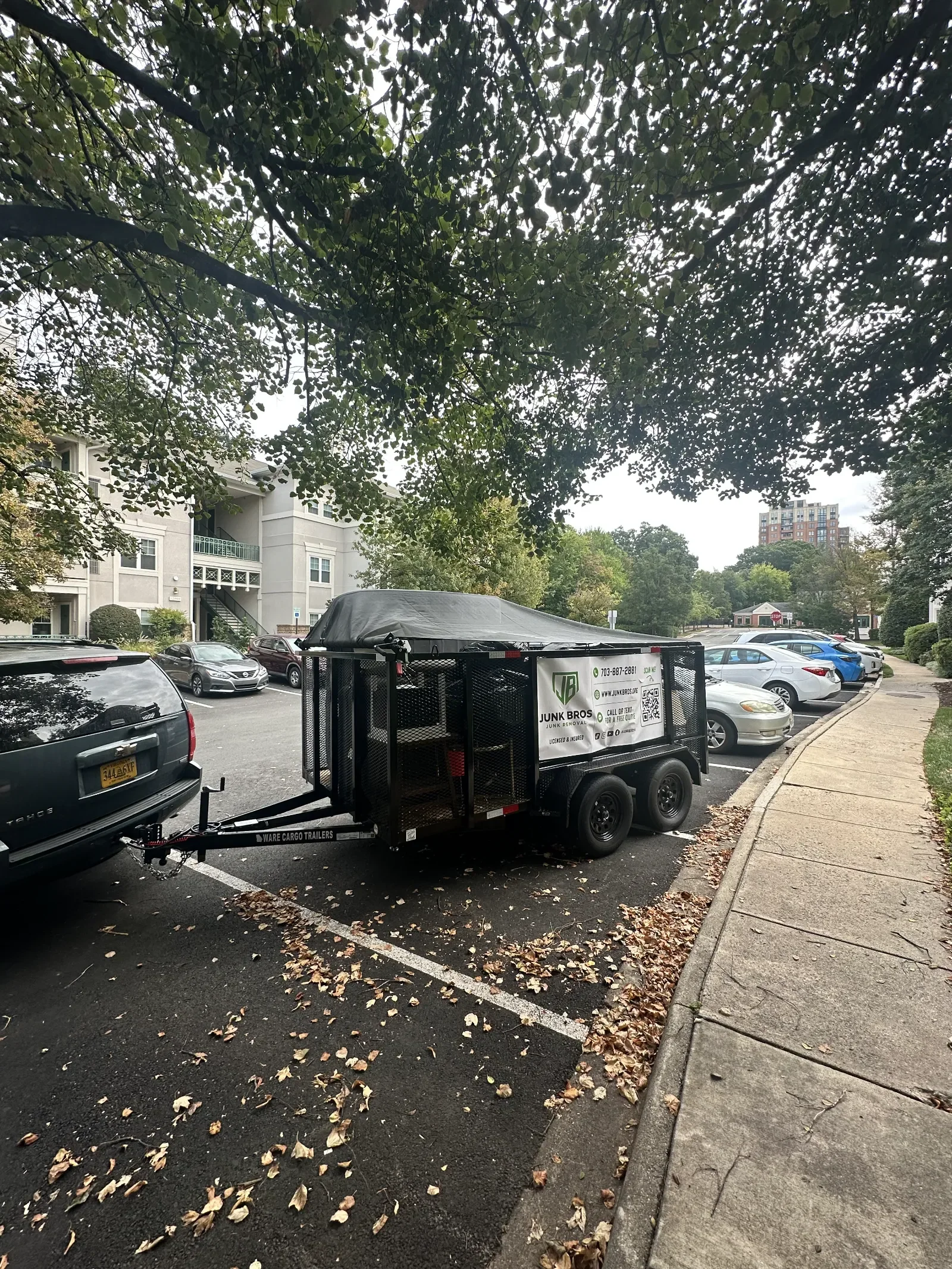 Tarped Junk Bros trailer loaded after a light demolition job at an apartment community in Virginia