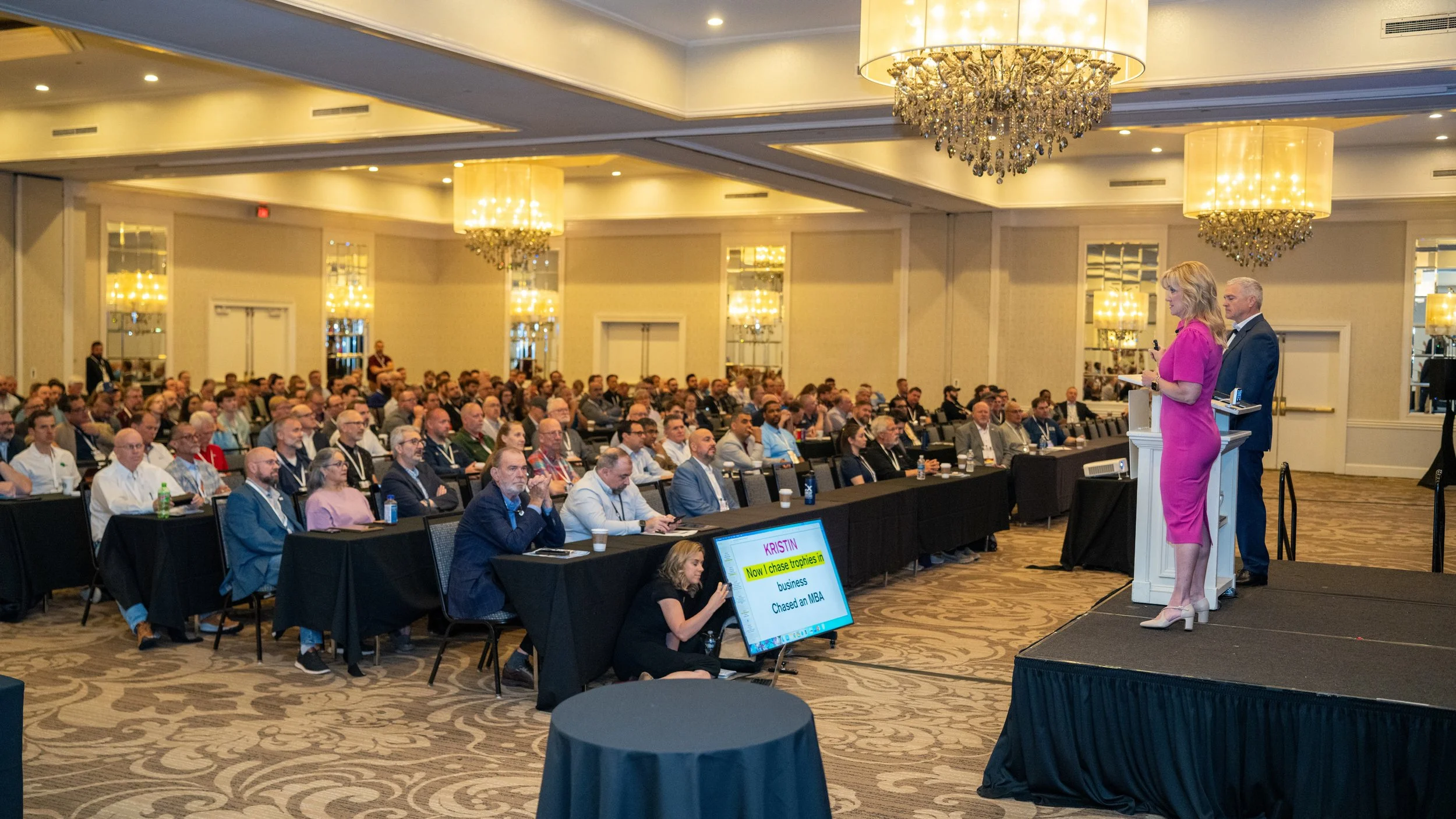 Communications Strategist Jennifer Moxley works as her clients speak on stage at a conference in Charlotte, NC