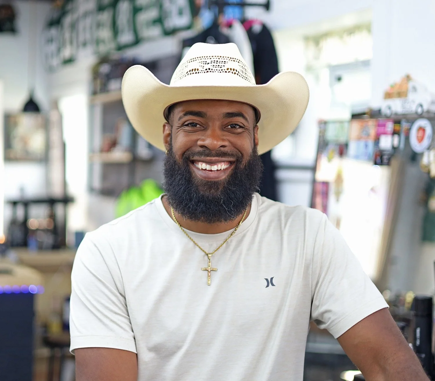 Hansel Canady smiling and wearing a cowboy hat and white t-shirt