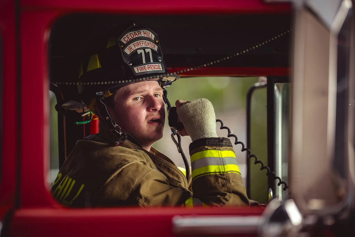 portrait of volunteer high school firefighter in firetruck