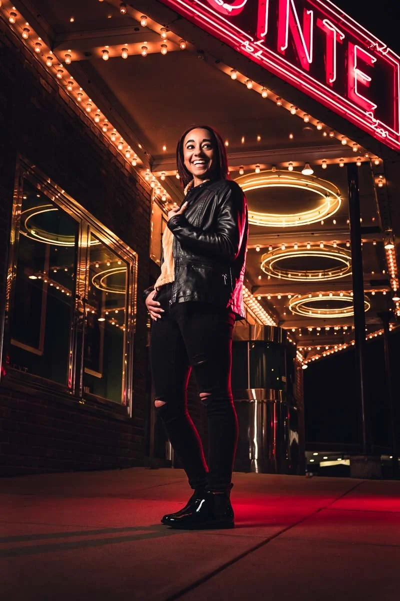 female senior posing in front of movie theater