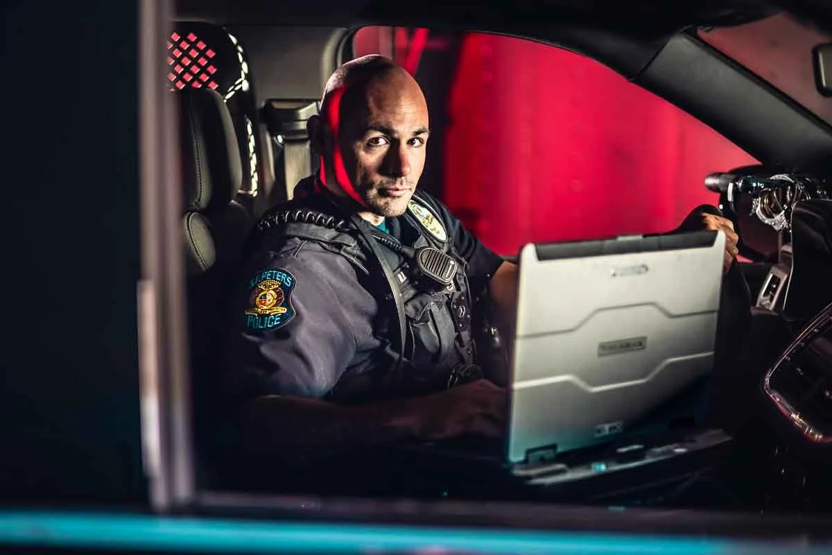 police officer in his cruiser vehicle with dramatic lighting