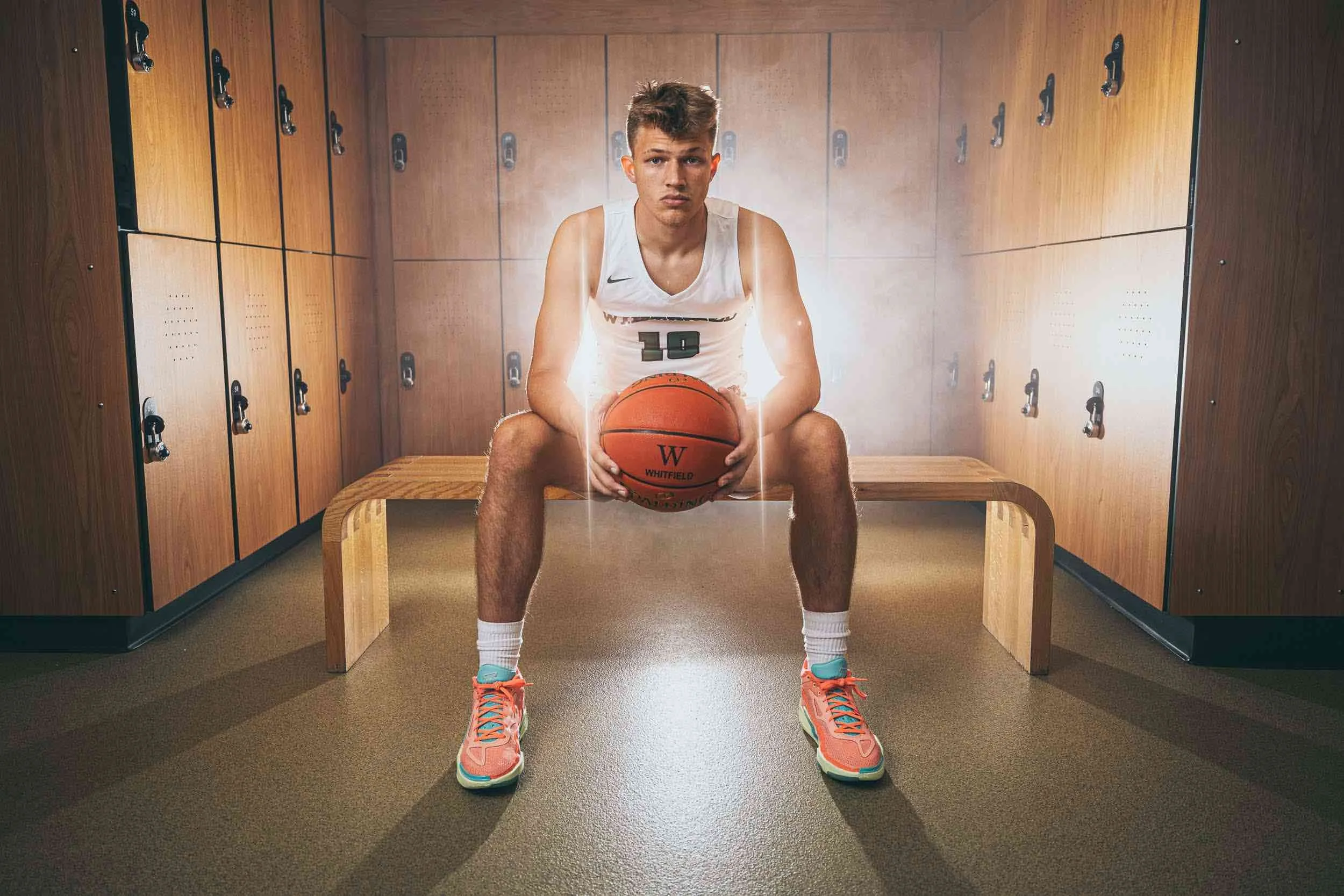 High school portrait of basketball athlete in locker room