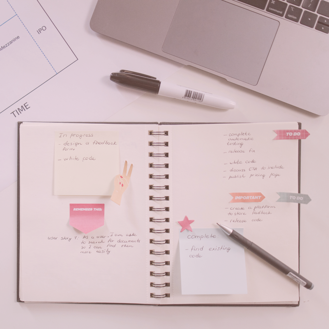 Daily planner with post-it notes a pencil a marker and a laptop