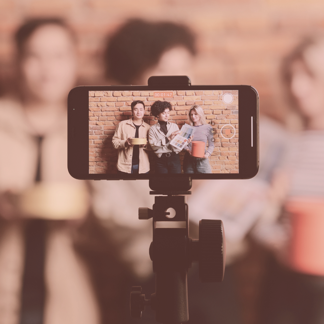Cell phone capturing video of one man and two women