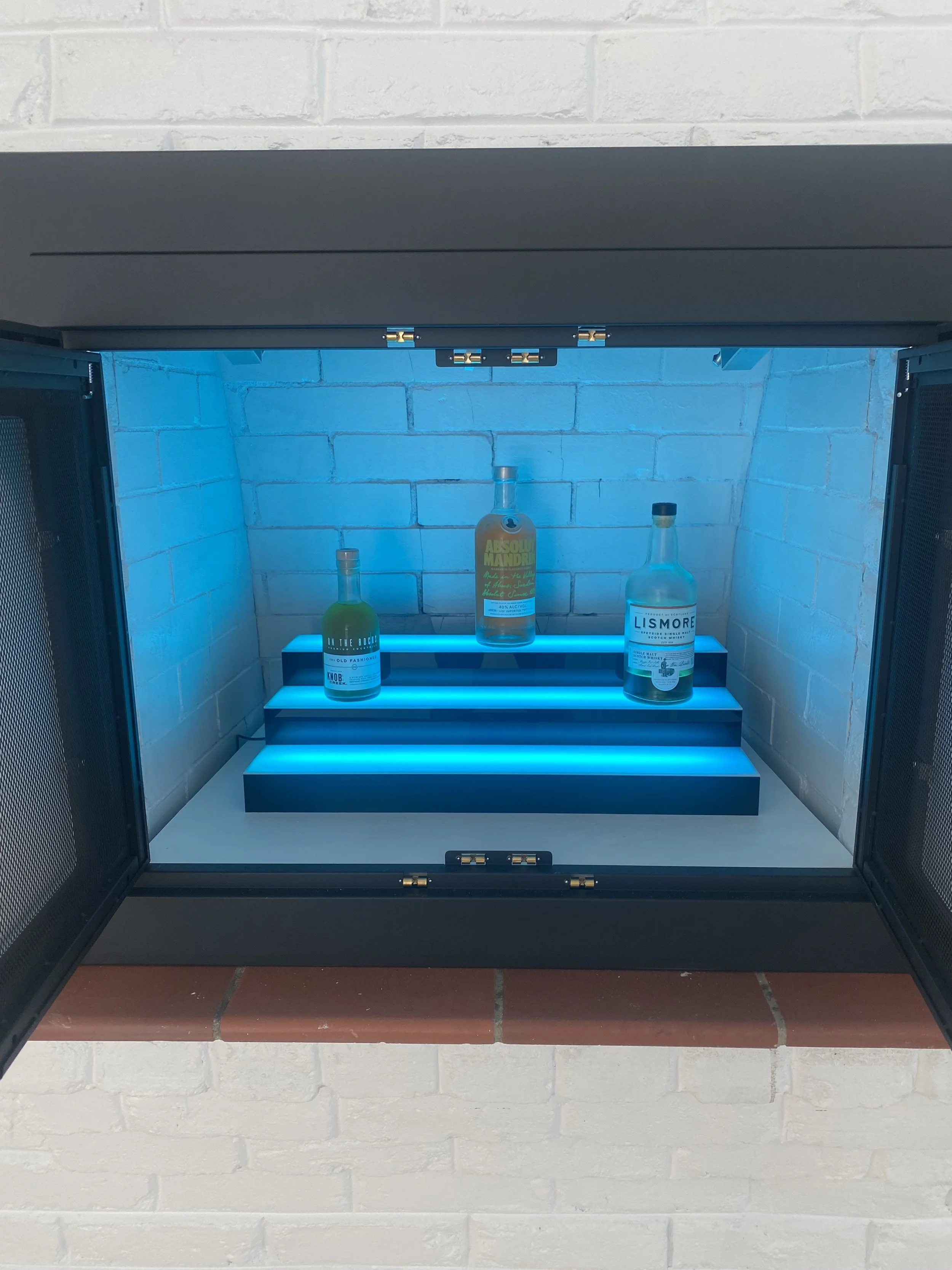 Repurposed unusable fireplace into an multi light LED infused family room bar