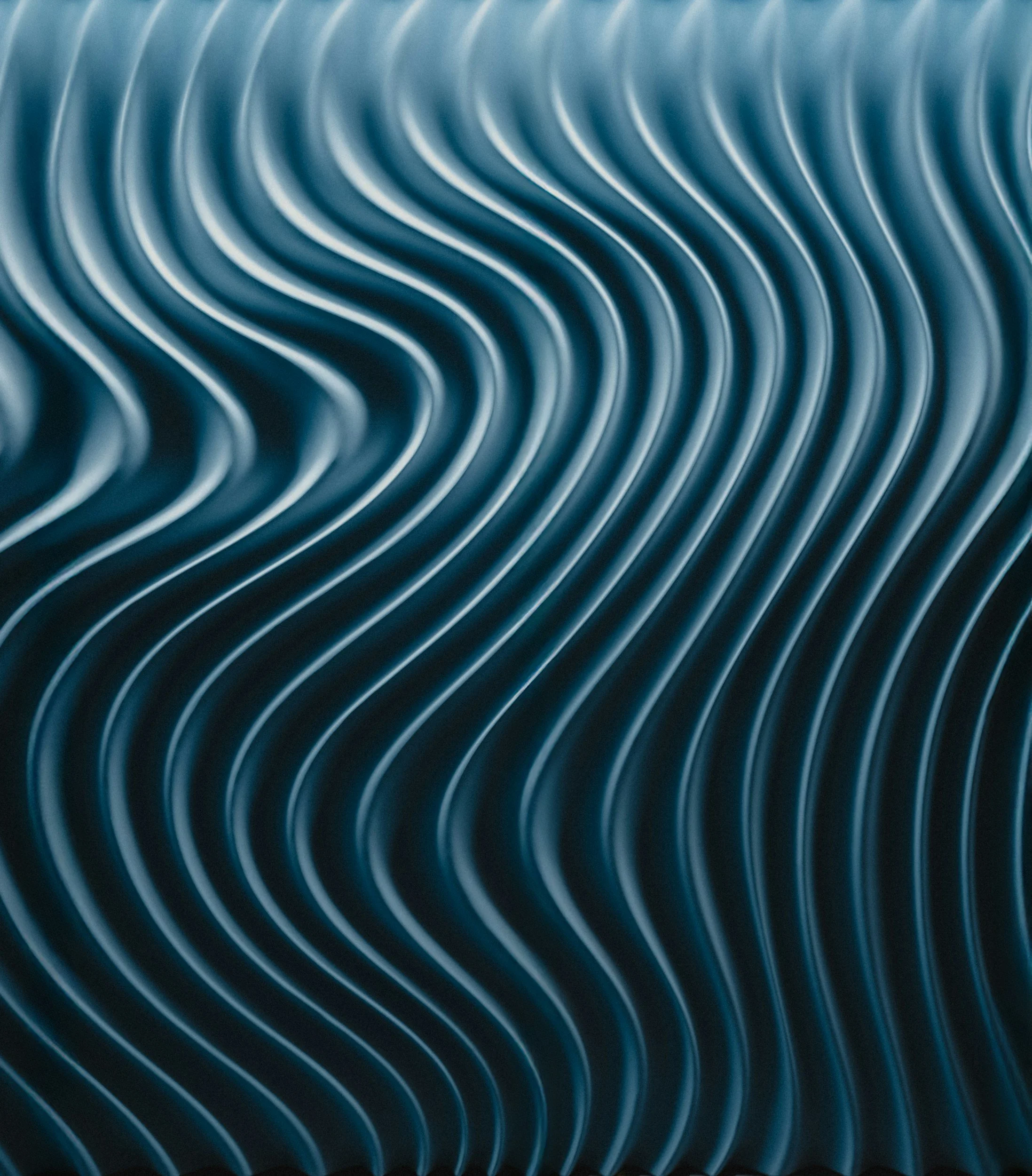 Close-up of metallic wavy parallel lines with a blue hue.