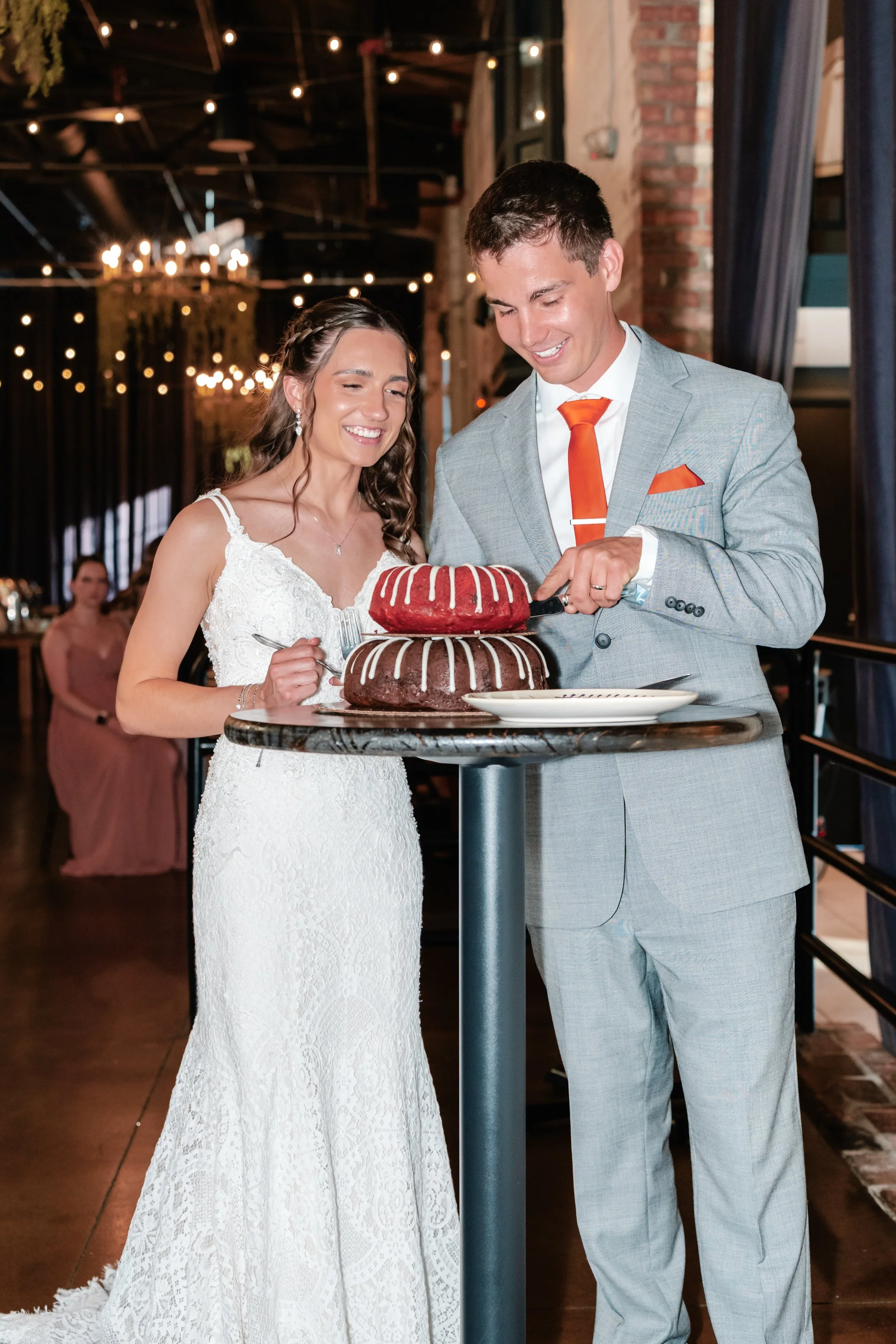Bride and groom cutting their wedding cake together at a reception.