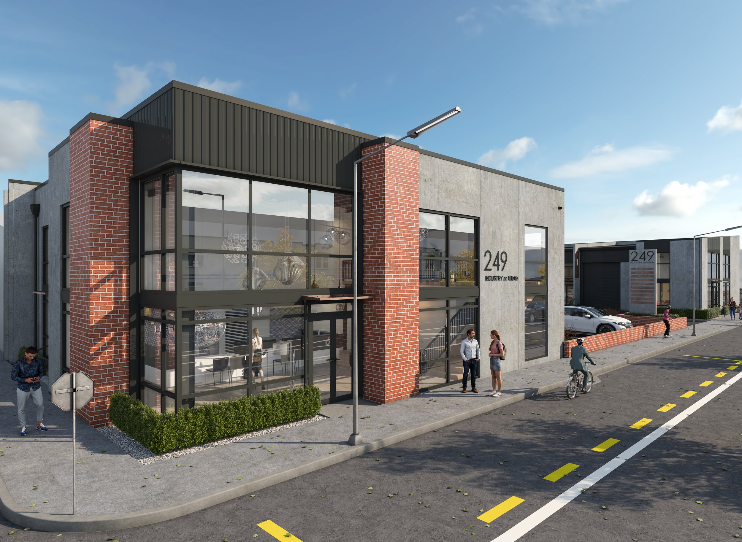 Modern commercial building with large glass windows, brick accents, and a sign reading '249 Industry on Hillside.' People walk and bike outside, with parking and street markings visible.