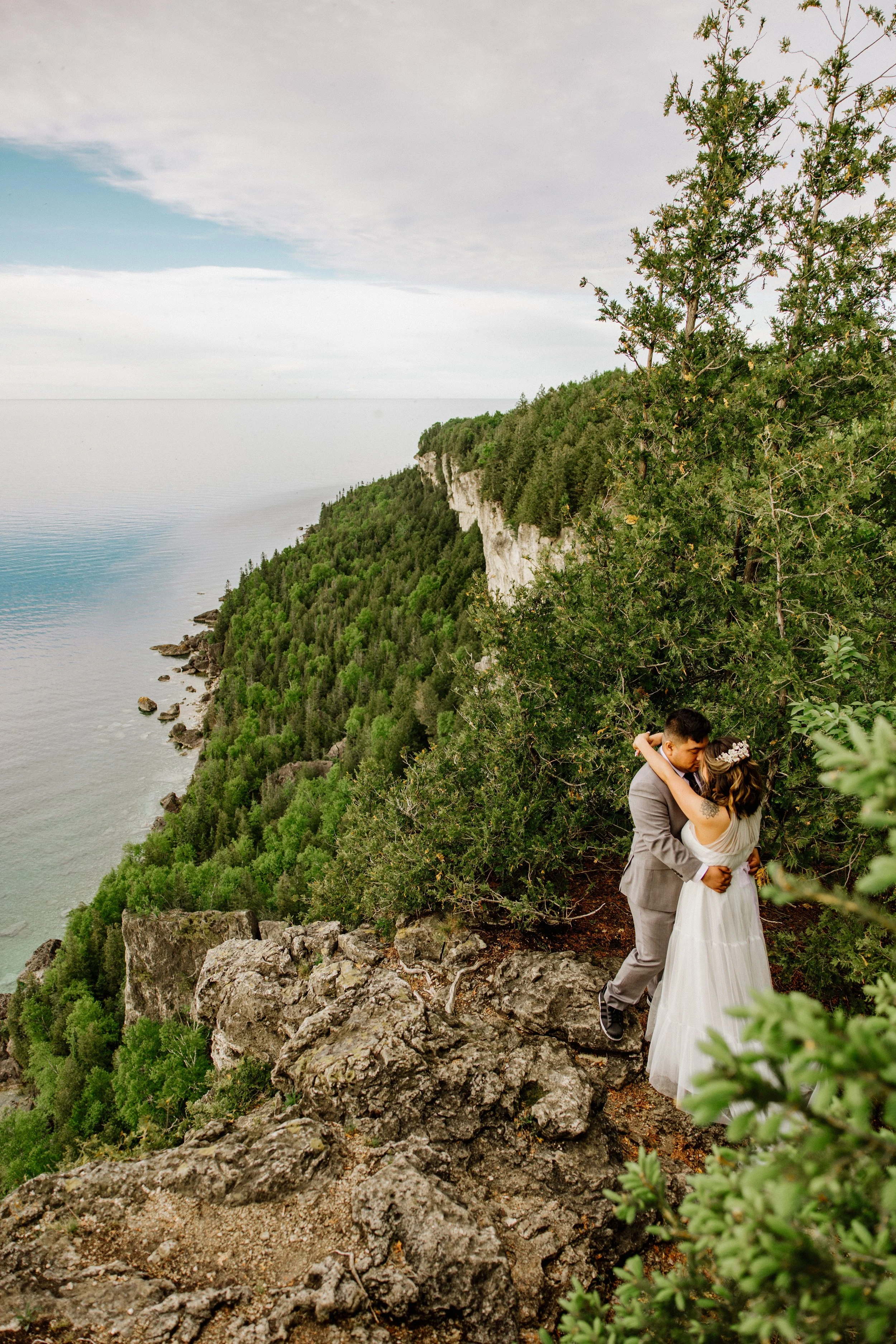 Laurie’s customers, Mariana and Carmen holding hands on a green lawn on their wedding day.