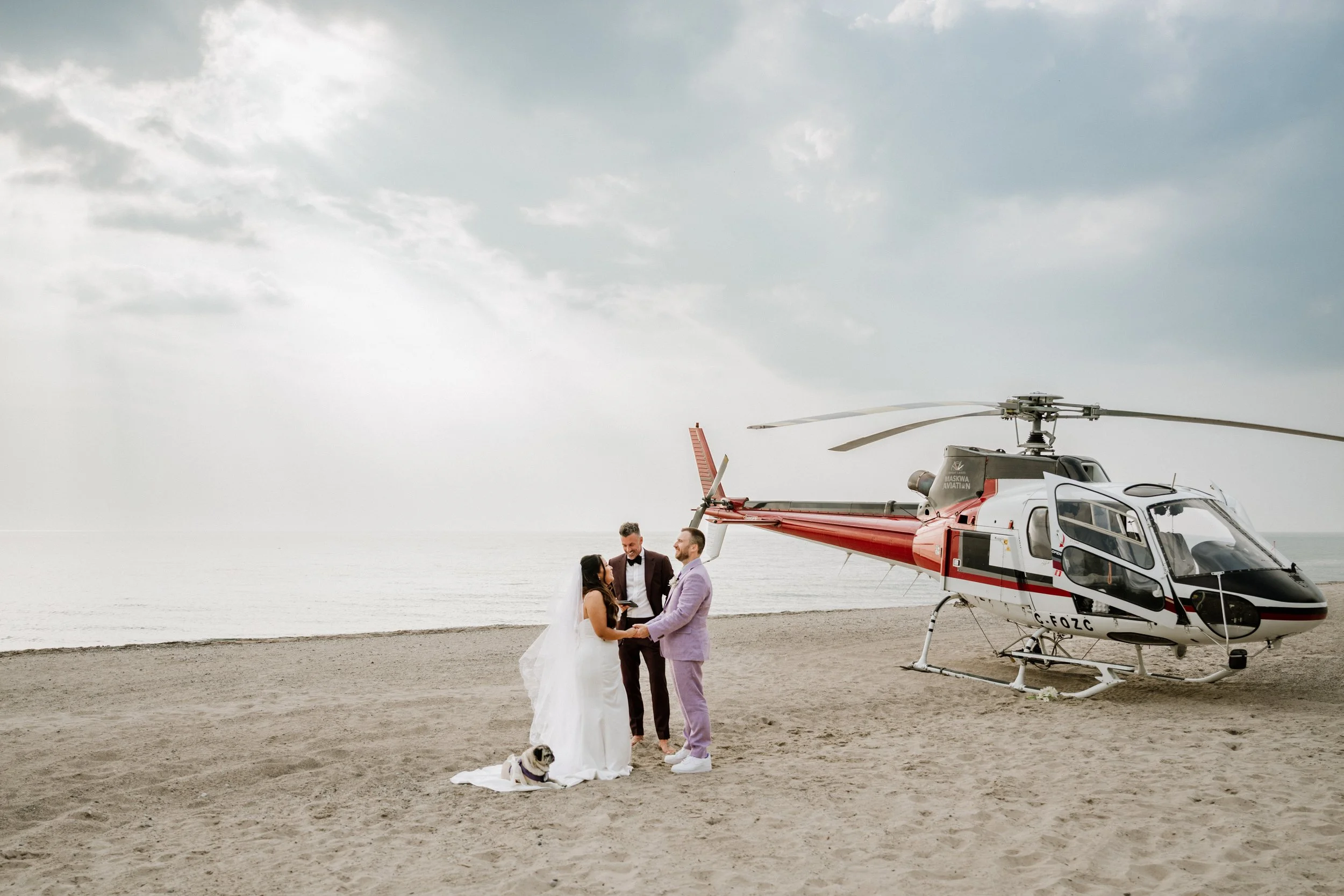 Laurie’s customers, Mariana and Carmen holding hands on a green lawn on their wedding day.