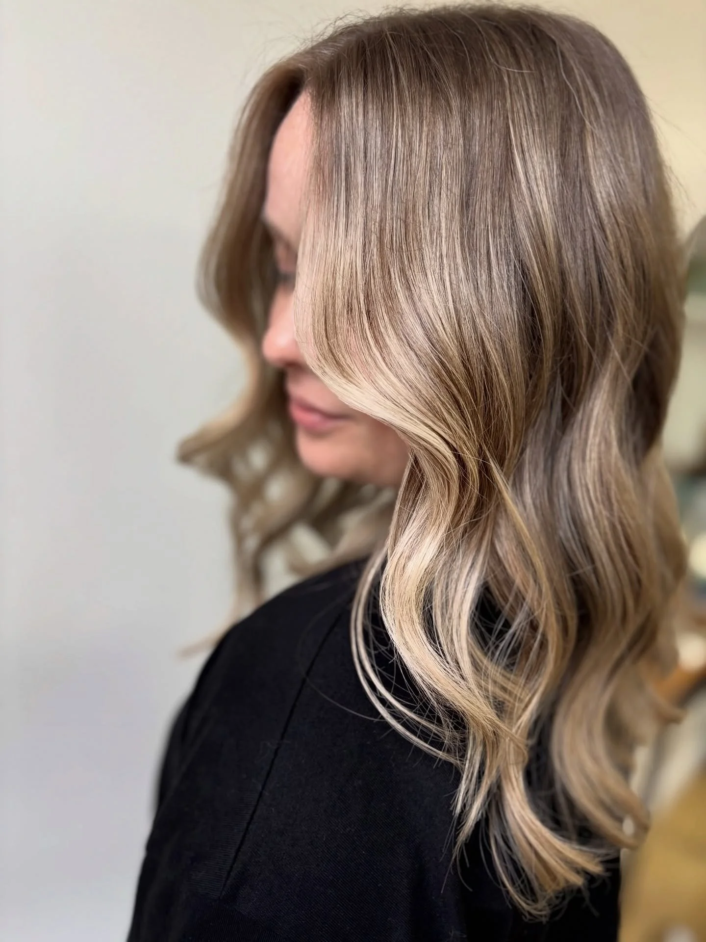 Karen spent almost a year and a half growing out her previously blonded hair to achieve this soft, dimensional monochromatic blonde. 

This is a very tone-on-tone look, with blended, &ldquo;barely there&rdquo; sun-kissed highlights. Not only is this 