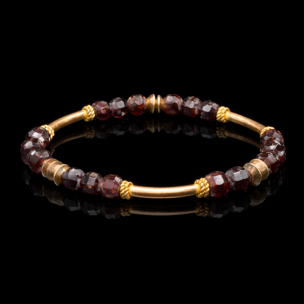 Gold and garnet beaded bracelet on a black background.