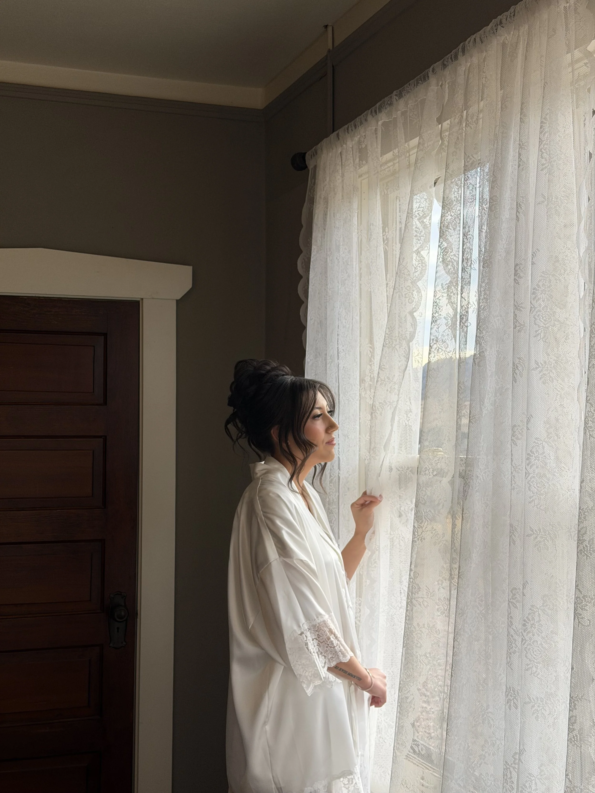 A bride in her getting ready outfit getting ready on her wedding day