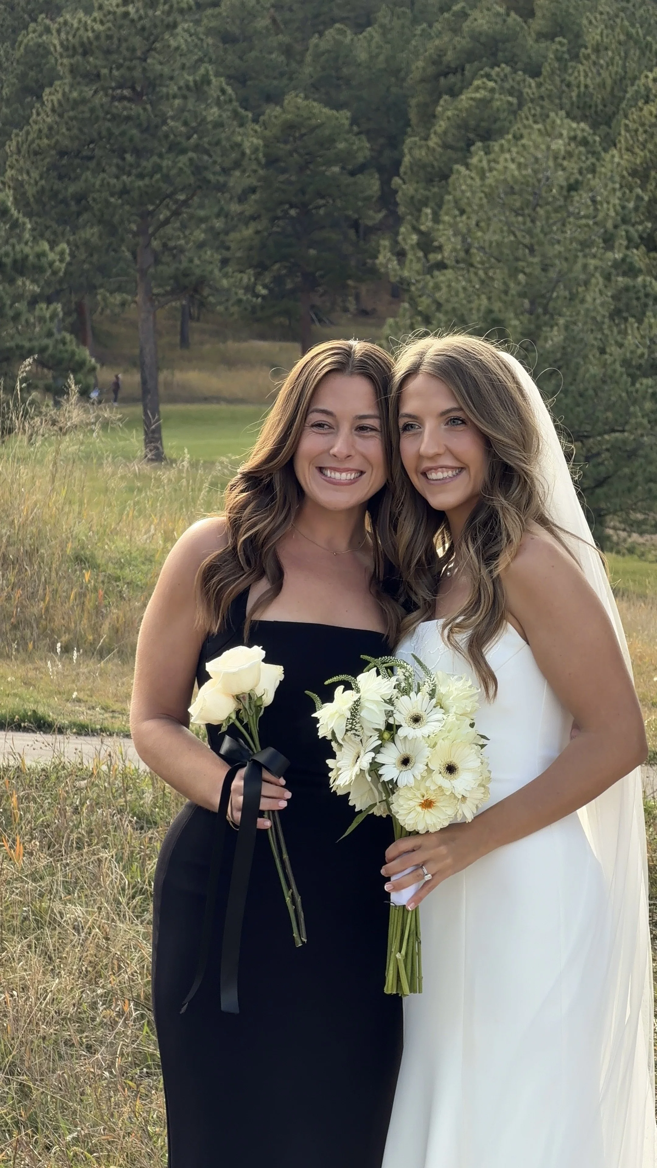 Bride and her bridesmaid posing for a picture they'll have forever
