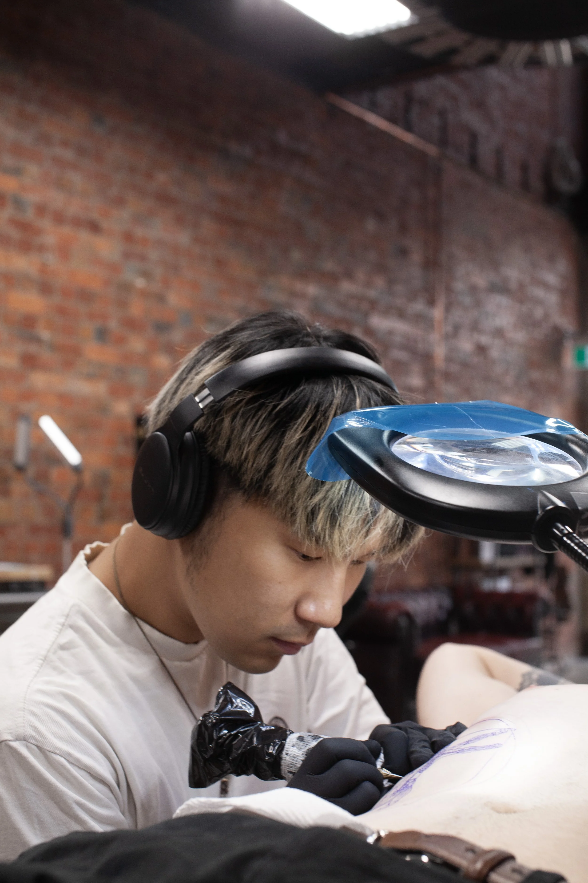 Hangang tattooing a client