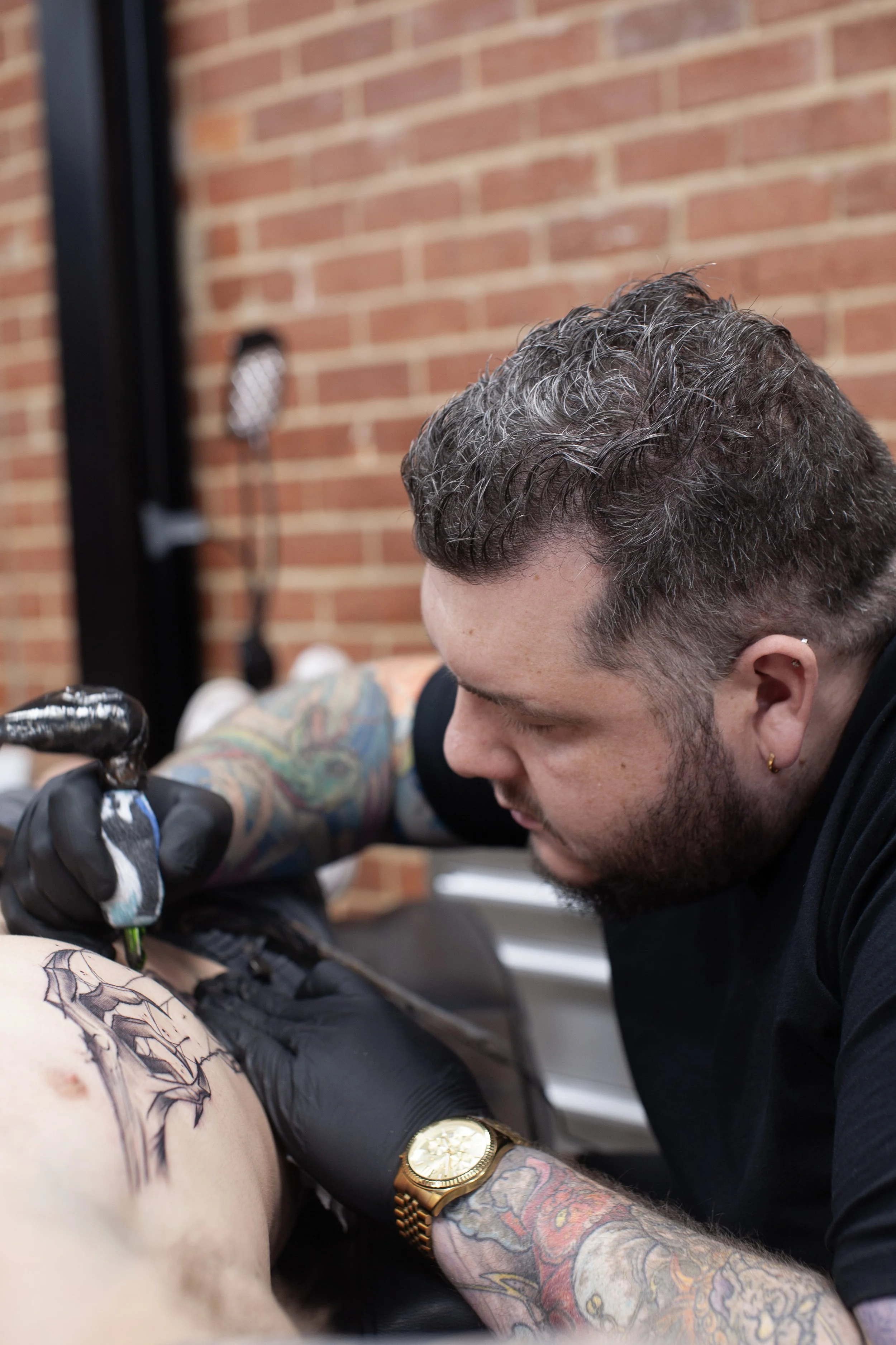 Tommy Rattle tattooing a client