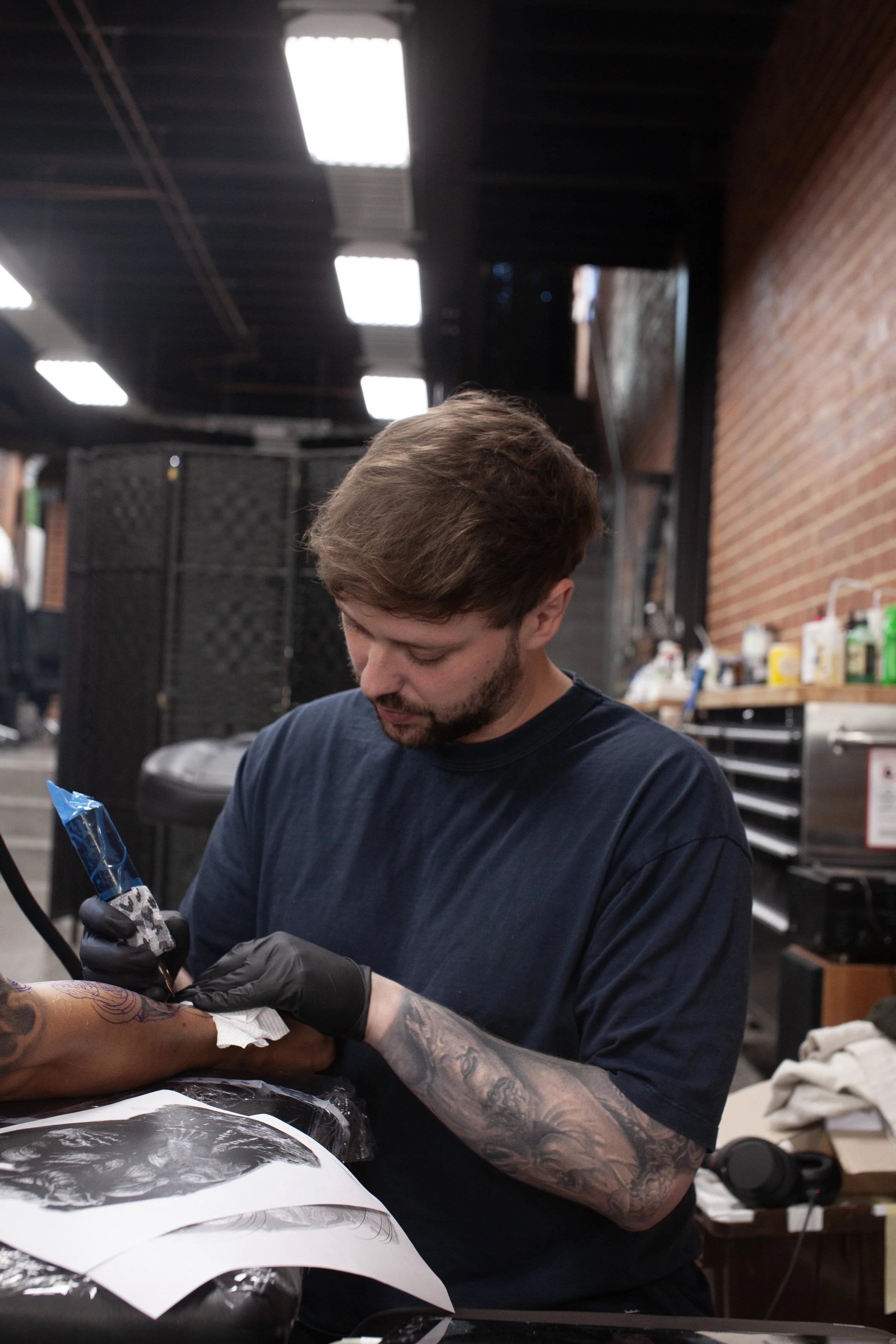 Tobias Meredith tattooing a client