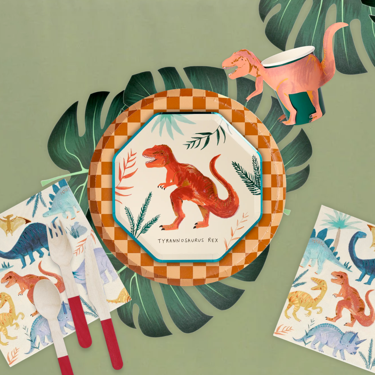 A dinosaur-themed party with a Tyrannosaurus Rex dessert plate, brown checkered dinner plate, and napkins featuring dinosaur illustrations, placed on a green table with tropical leaves, accompanied by a spoon and fork with red handles.