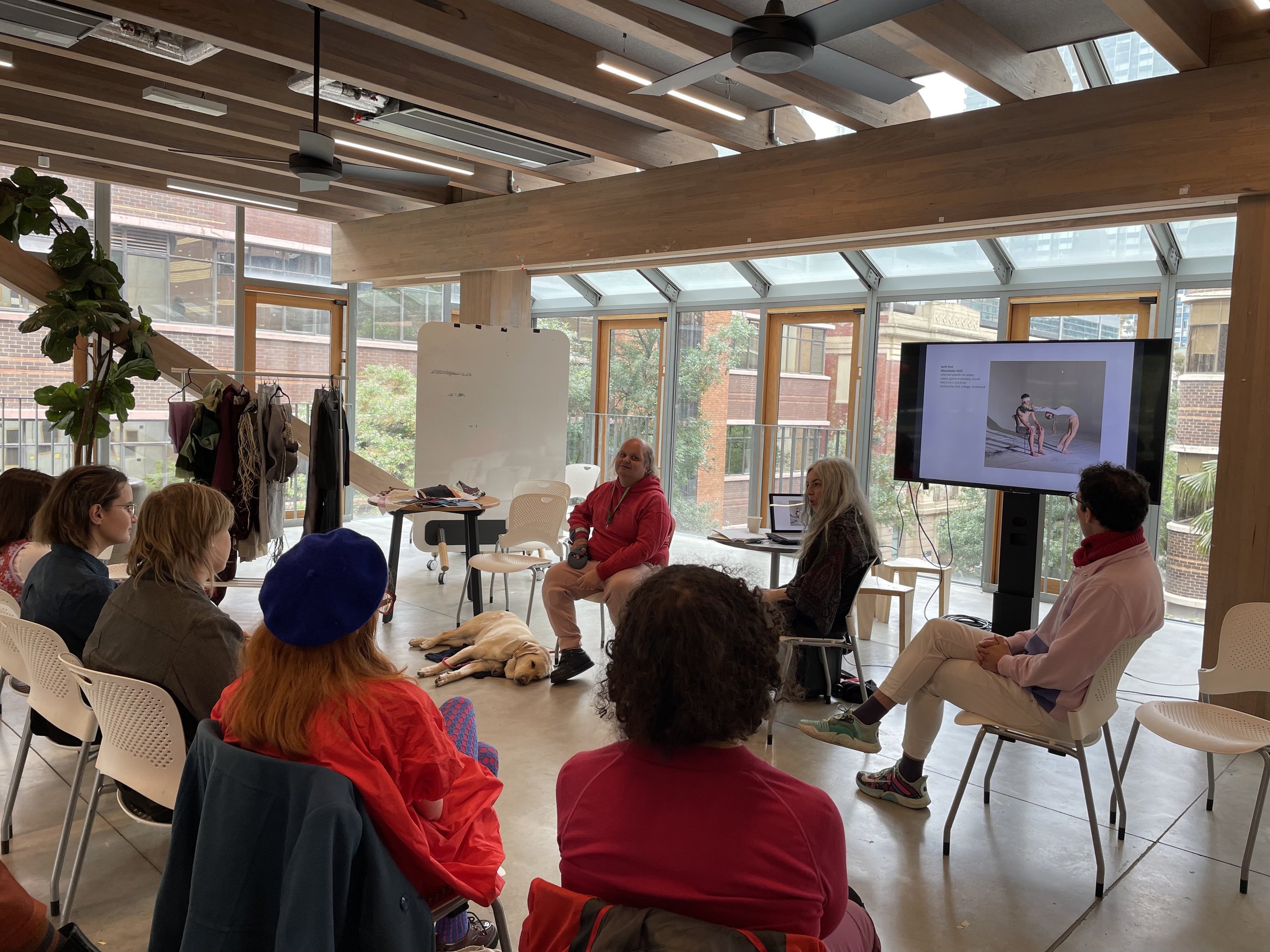 Workshop participants are seated for a discussion between lived experience and accessibility experts.