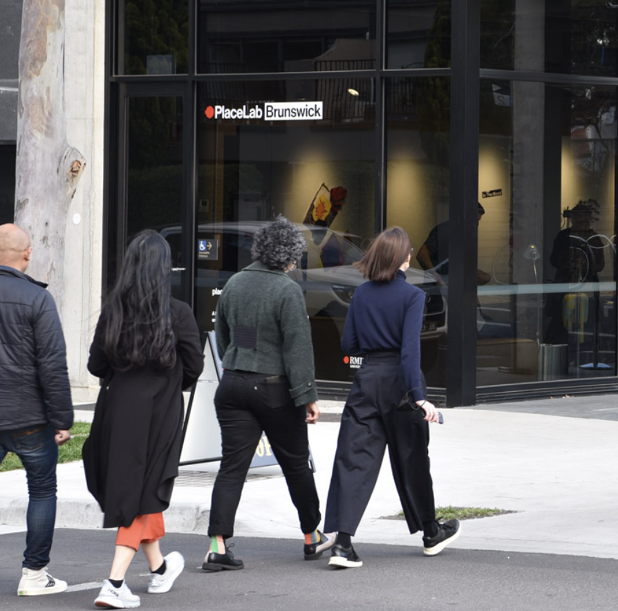 Julie leads a small group of people along an urban street.