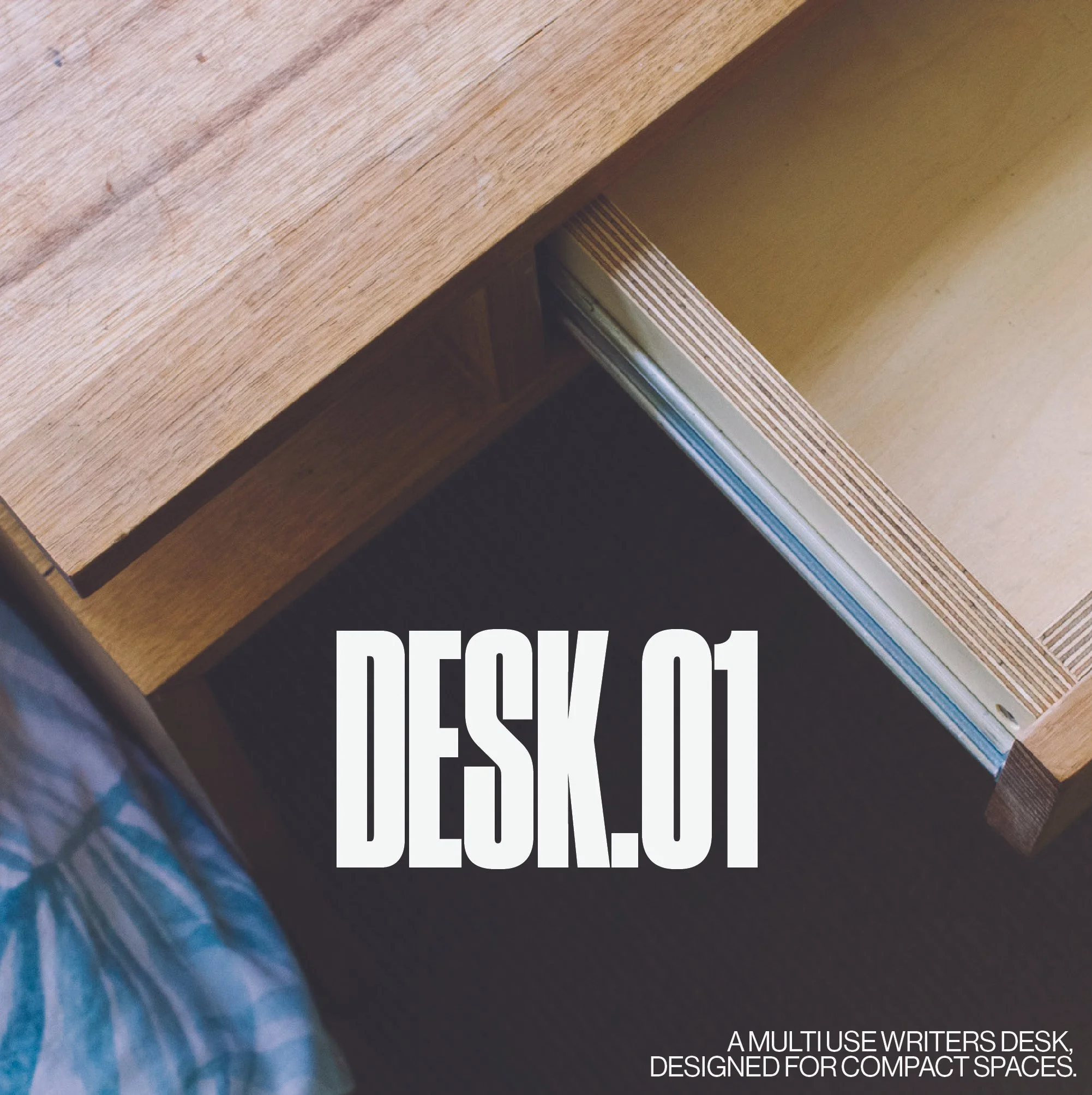 Close-up image of a wooden desk with visible wood grain and edges, overlapping a section with black background and white text. The visible text says 'A MULTIUSE WRITERS DESK, DESIGNED FOR COMPACT SPACES.' The bottom right corner contains smaller white text.