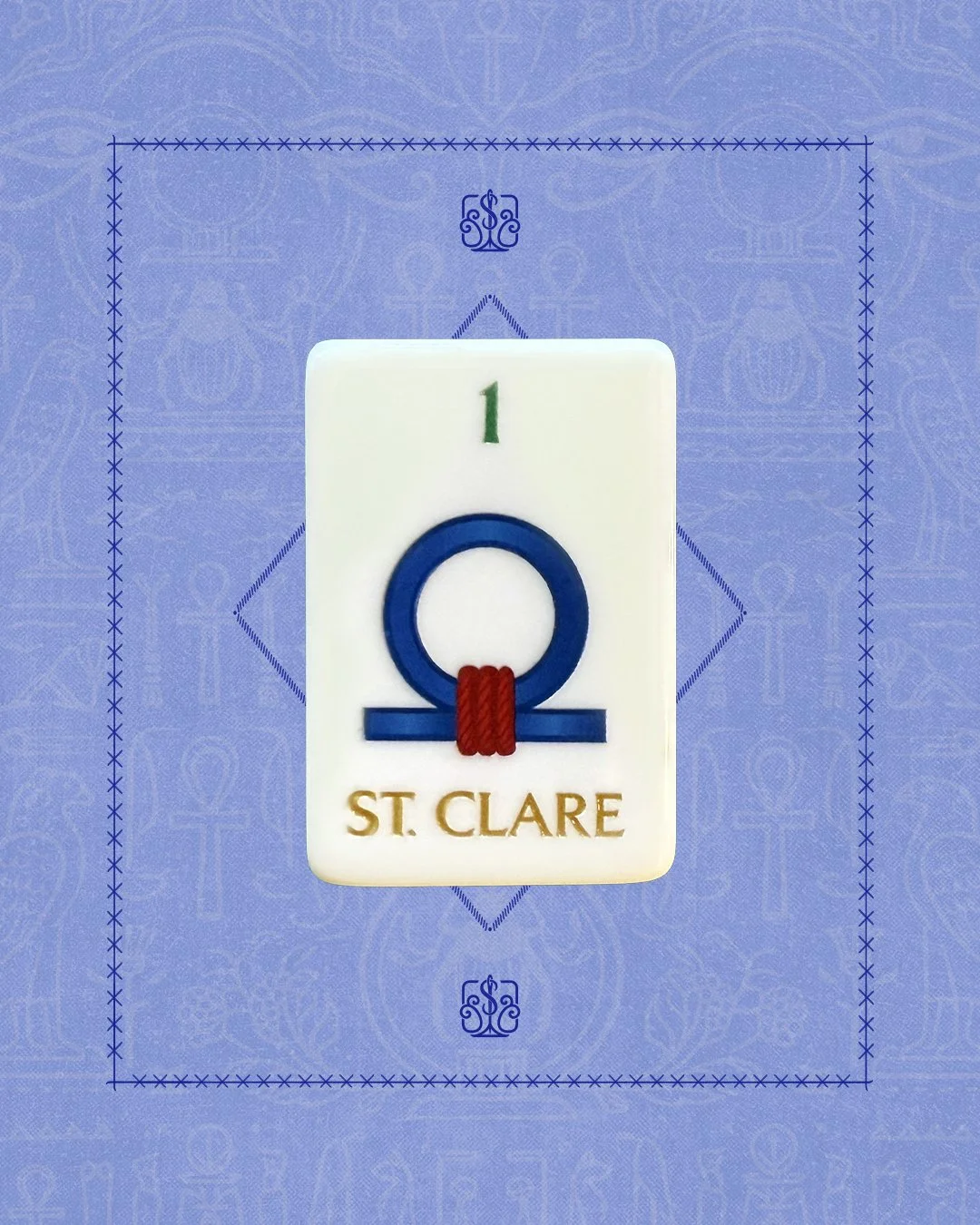A tile with the Greek letter Omega and the text 'ST. CLARE' beneath it, placed on a blue decorative background.