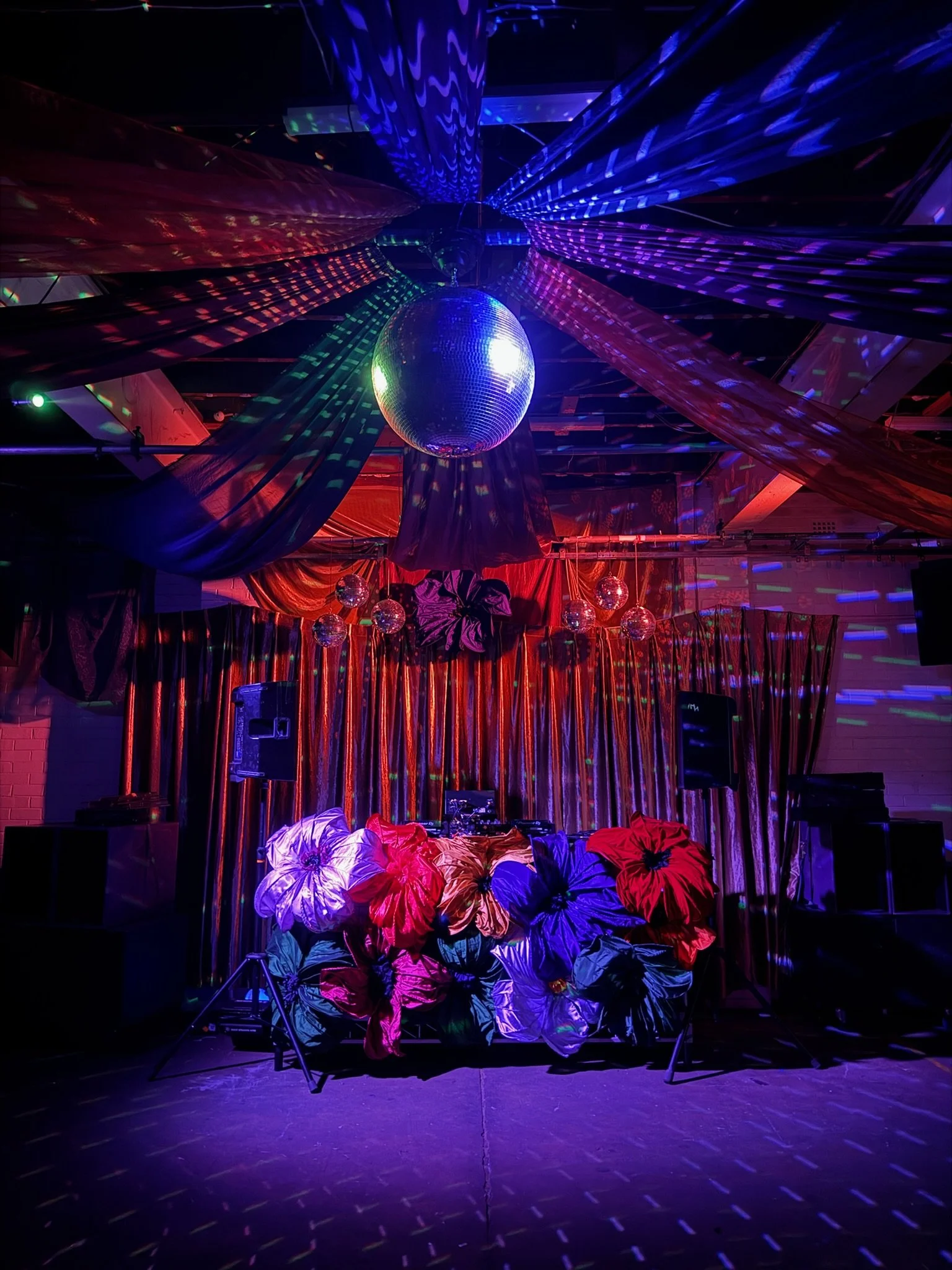 Full venue take over with DJ booth decorations, disco ball & backdrop with drapes