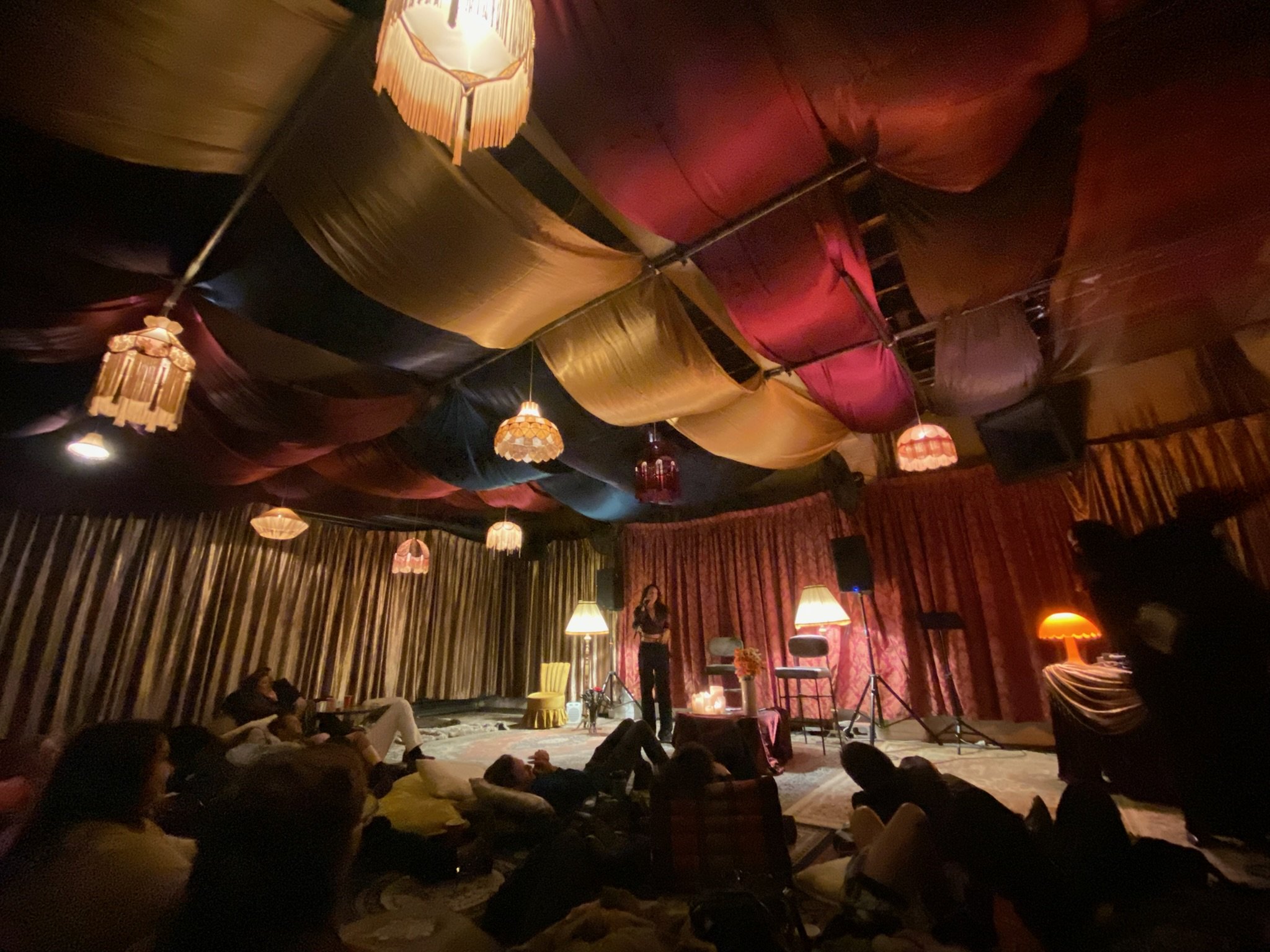 Complete venue takeover turning a warehouse into a velvety soft secret lounge with ceiling drapery, gold curtains & rugs