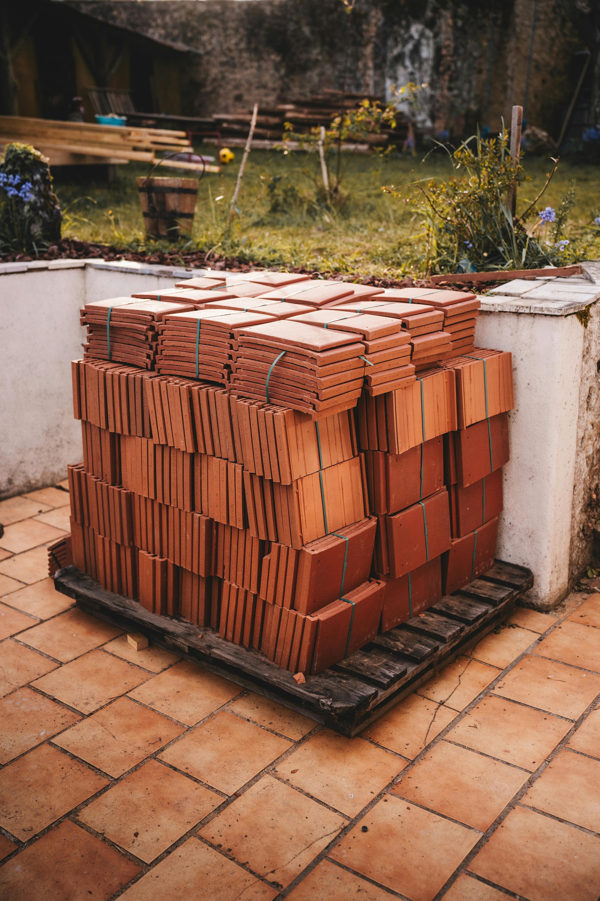 Pallet of organized red clay bricks stacked outdoors on a wooden pallet