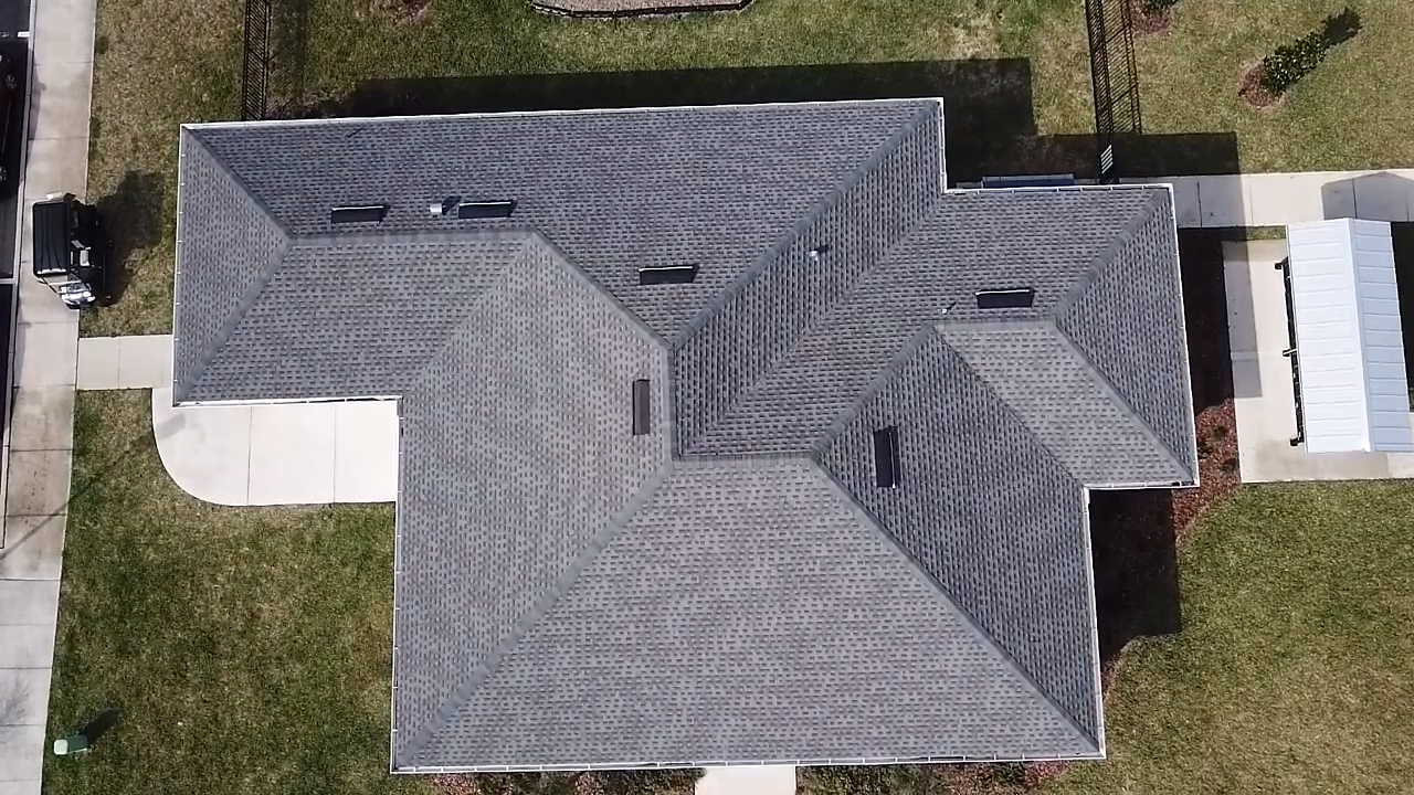Aerial view of a house with a multi-gabled roof, that was just replaced.