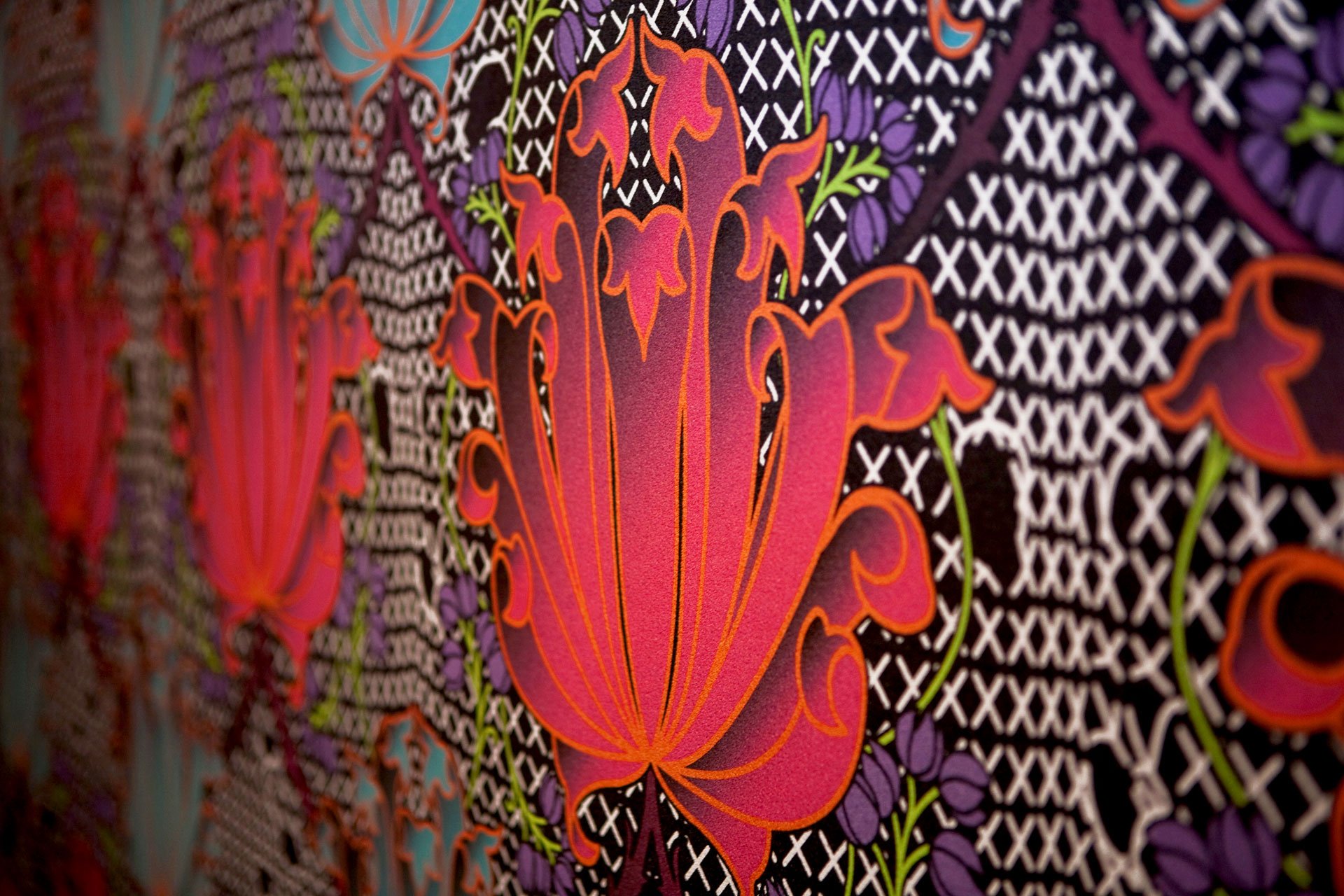 Detail of Laruche wallpaper by KT Doyle showing vivid red and purple floral forms layered over contrasting geometric patterns