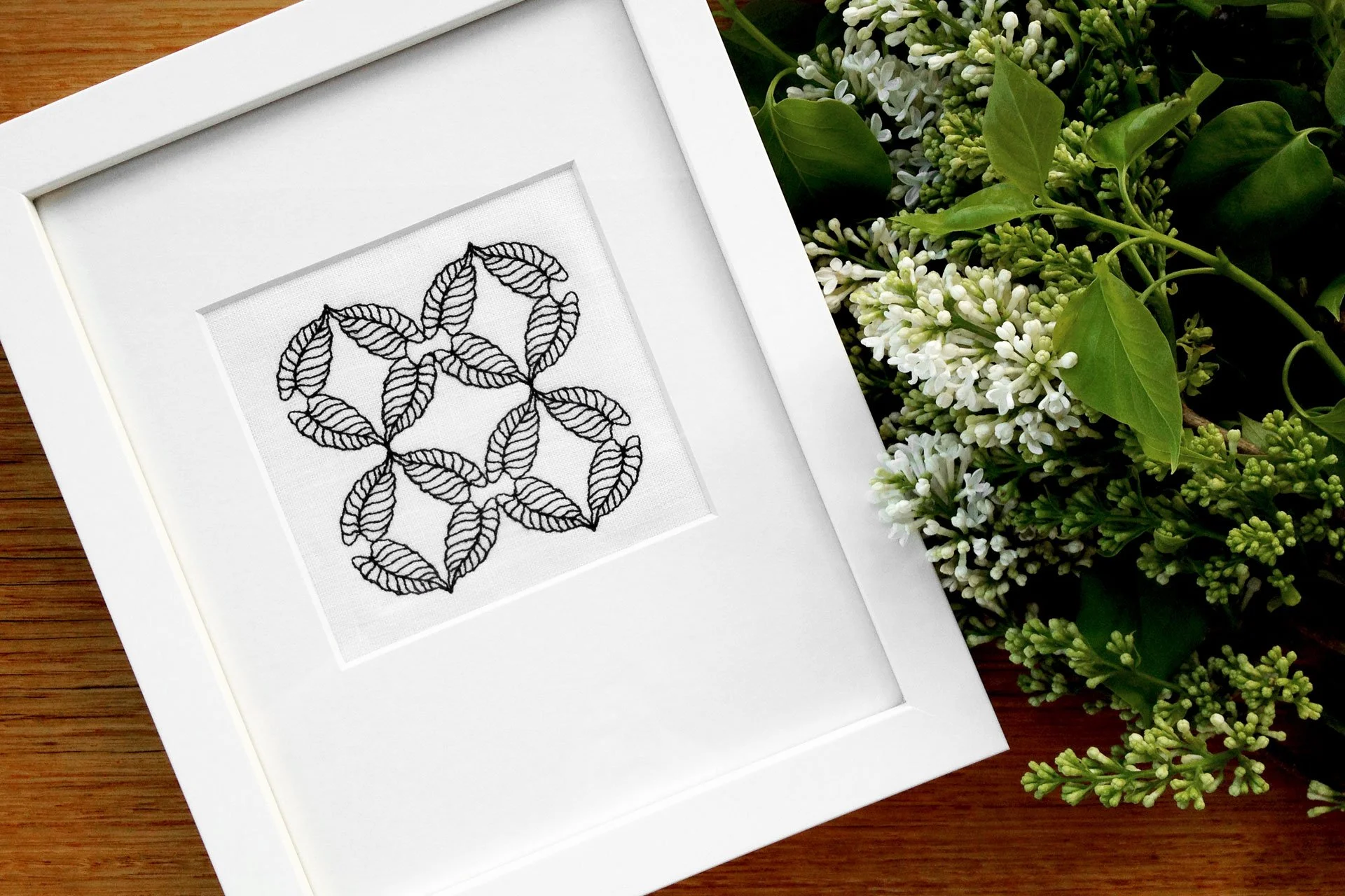 CP2 botanical embroidery from the Collected Patterns series by Australian artist KT Doyle, repeating Caladium leaves stitched in black on white linen