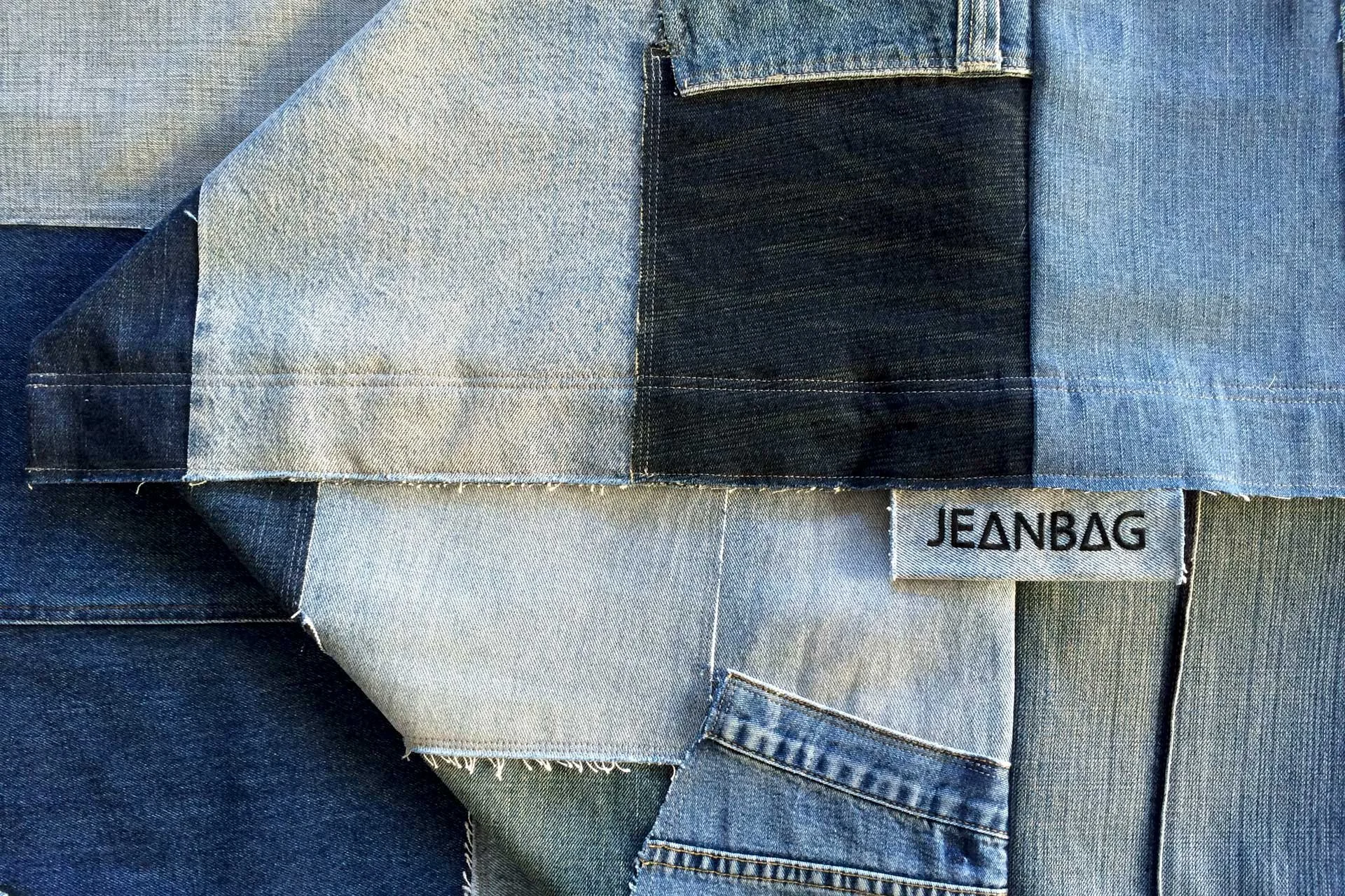 Detail of Original JEANBAG patchwork showing recycled denim pockets, seams and JEANBAG label