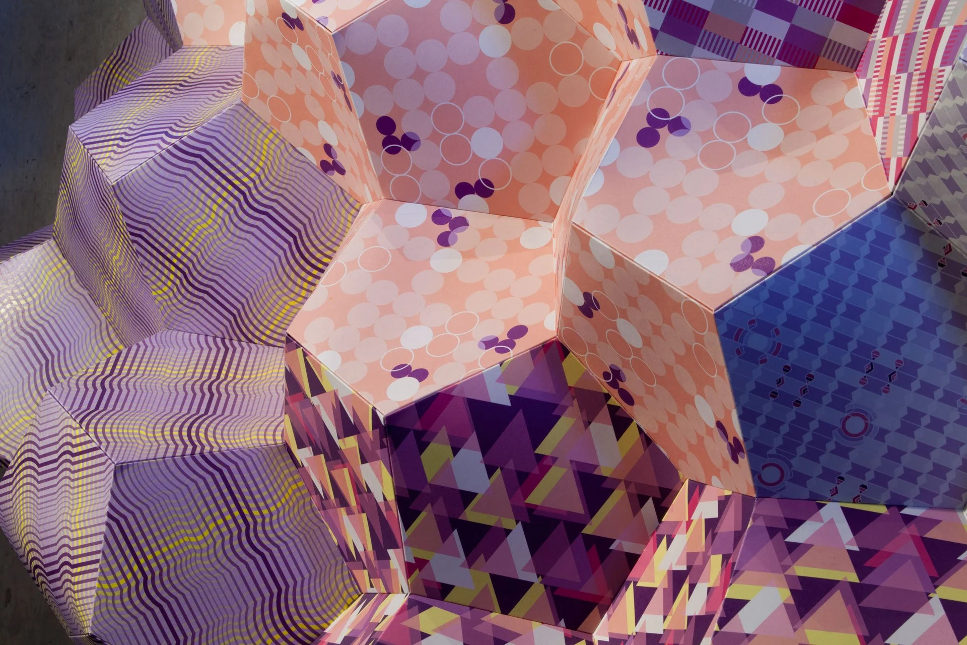 Close detail of Stitched Together showing KT Doyle's layered geometric patterns wrapping across the angular sculptural forms