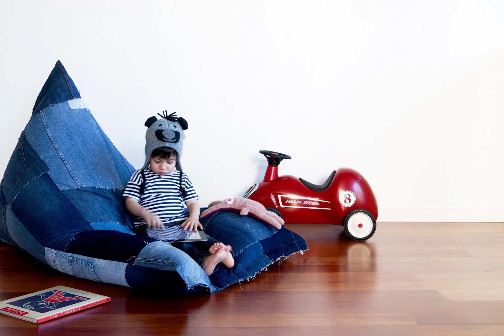 Child seated on an Original JEANBAG beanbag handmade from recycled denim
